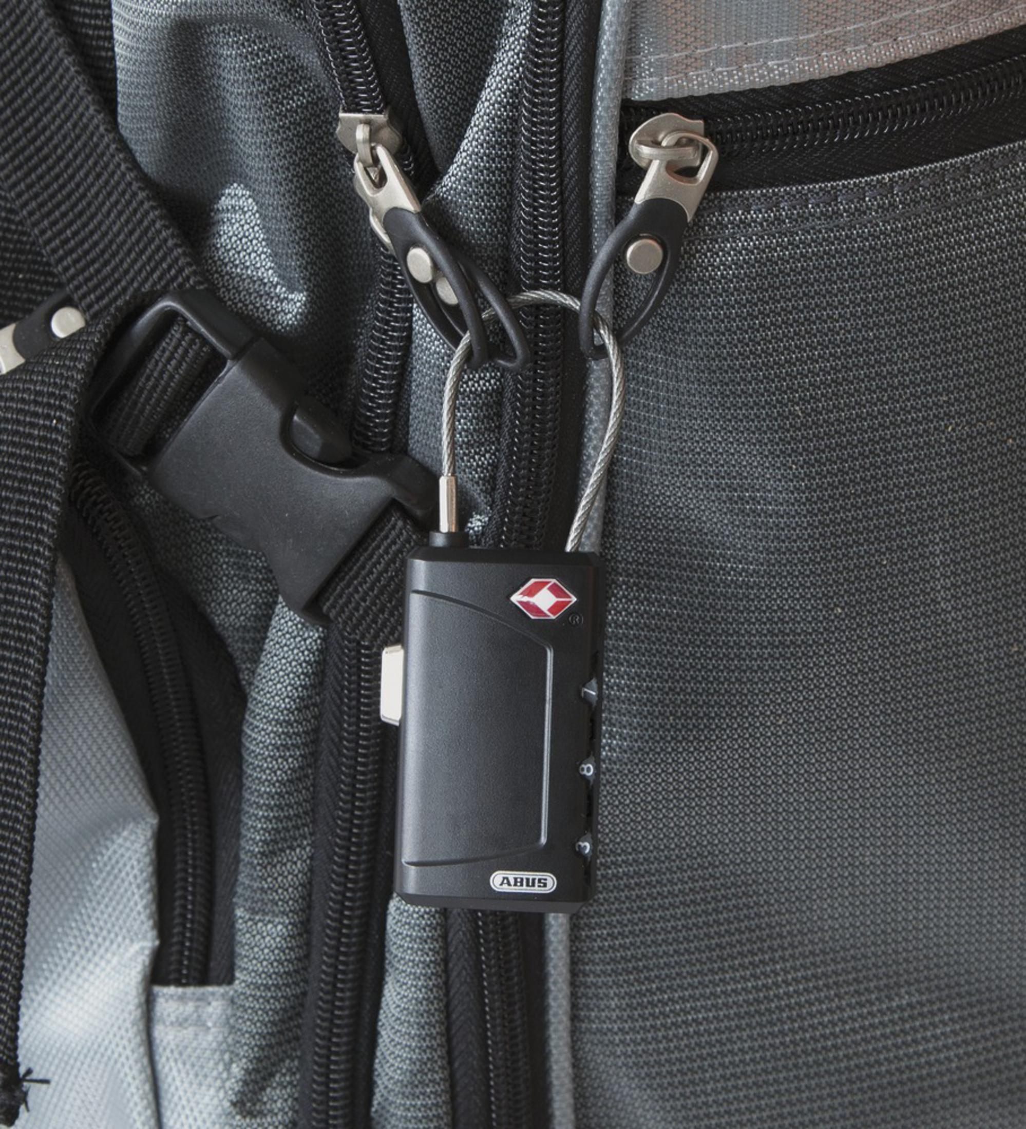 Ein schwarzes ABUS-Kombinationsvorhängeschloss sichert einen grauen Rucksack.
