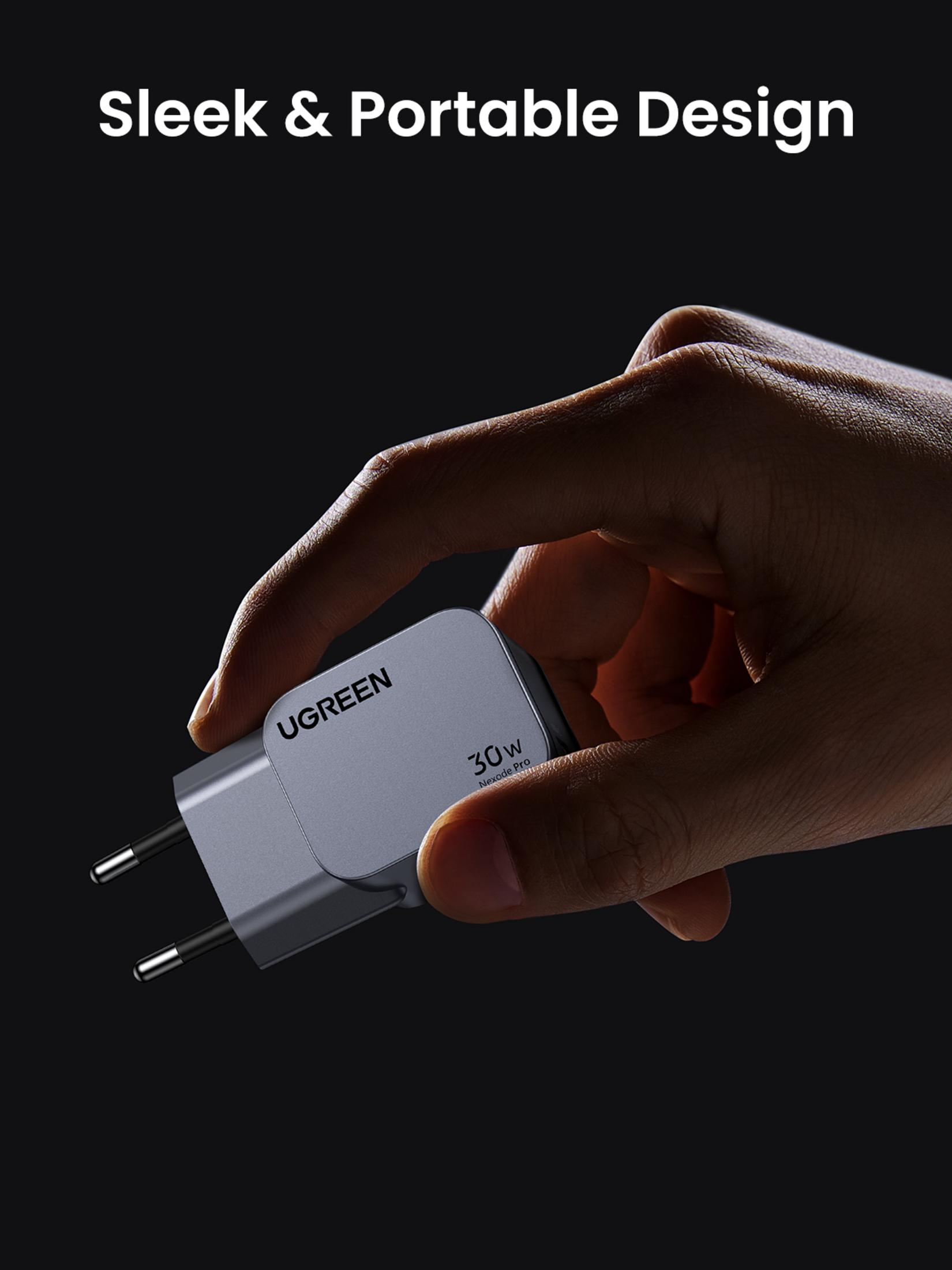 Ręka trzyma ładowarkę UGREEN 30W na ciemnym tle, podkreślając jej smukłą, przenośną konstrukcję.