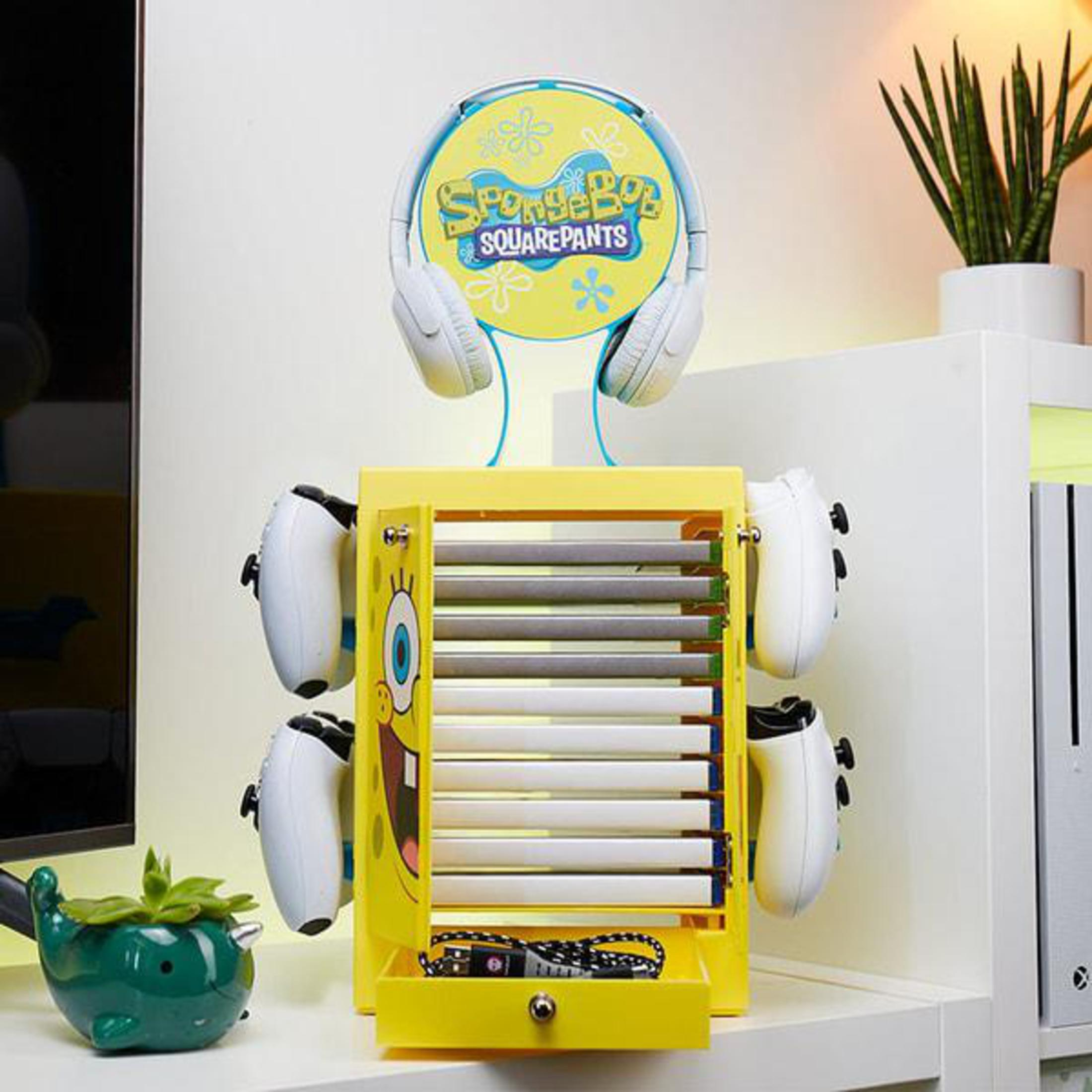 Organizzatore giallo di SpongeBob SquarePants che contiene gamepad, con cuffie sopra, in un ambiente domestico.