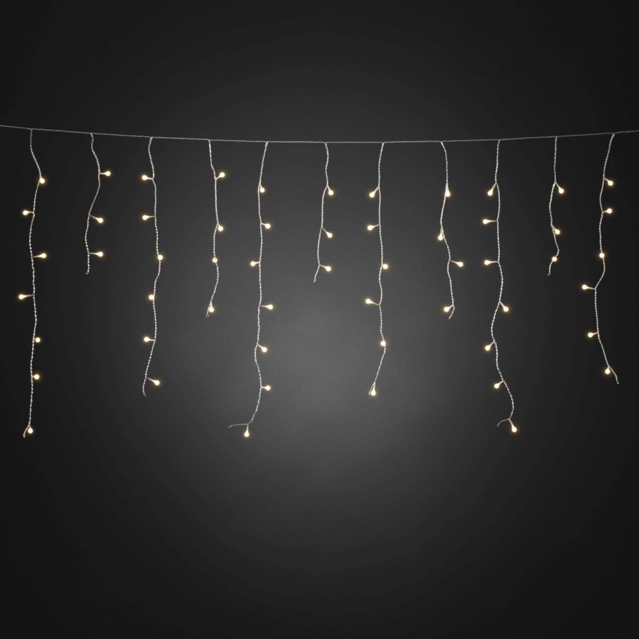 Stränge kleiner, warmweißer Lichterketten, die vor einem dunkelgrauen Hintergrund hängen.