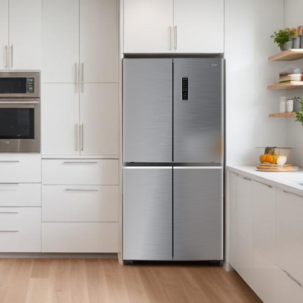 Un refrigerador gris está en una cocina blanca moderna con electrodomésticos de acero inoxidable y pisos de madera.