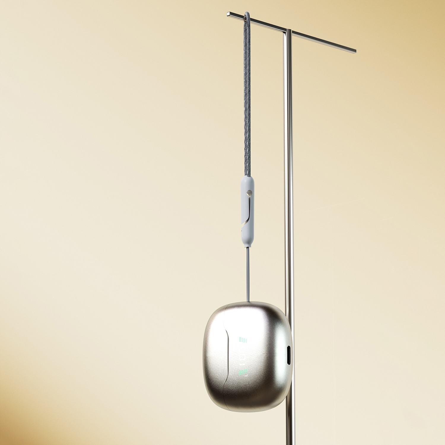 Zawieszone słuchawki i etui ładujące, srebrne etui i szary sznurek.