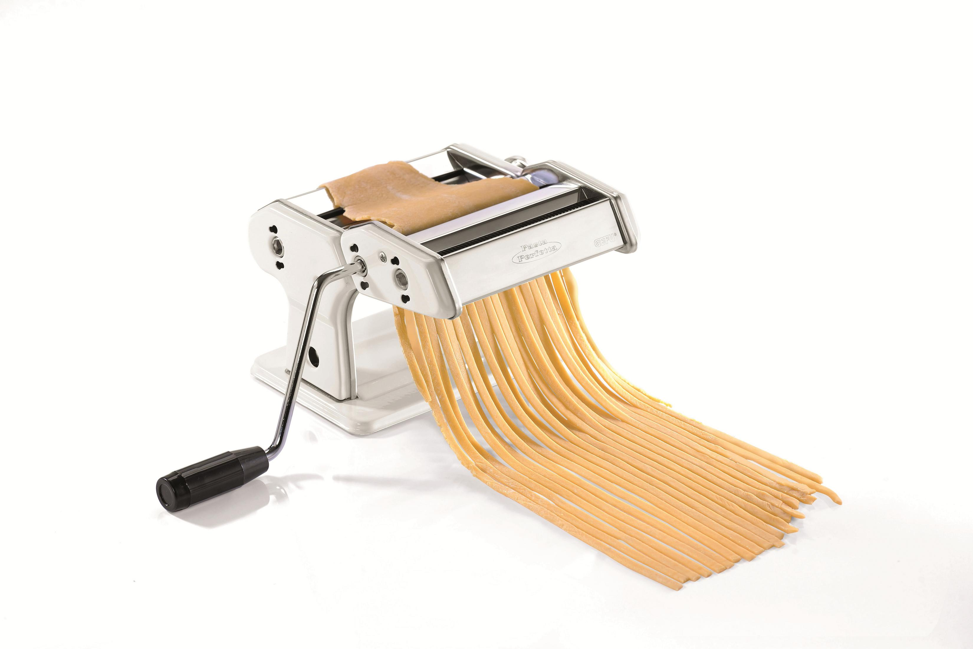 Una macchina per la pasta con una maniglia crea lunghi fili di pasta su uno sfondo bianco.