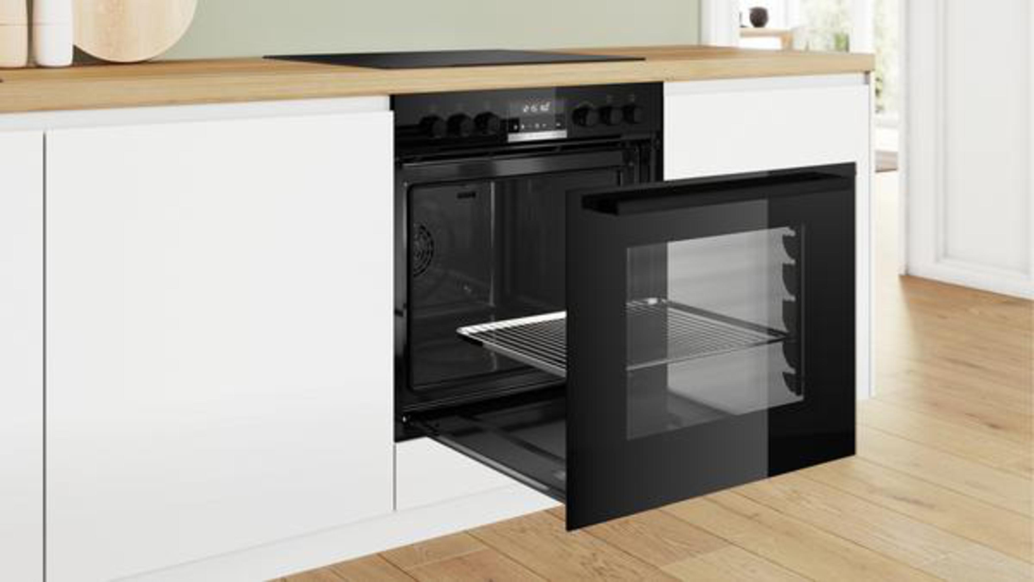Ein schwarzer Bosch-Backofen mit geöffneter Tür, die das Innere und einen Drahtrost freigibt.