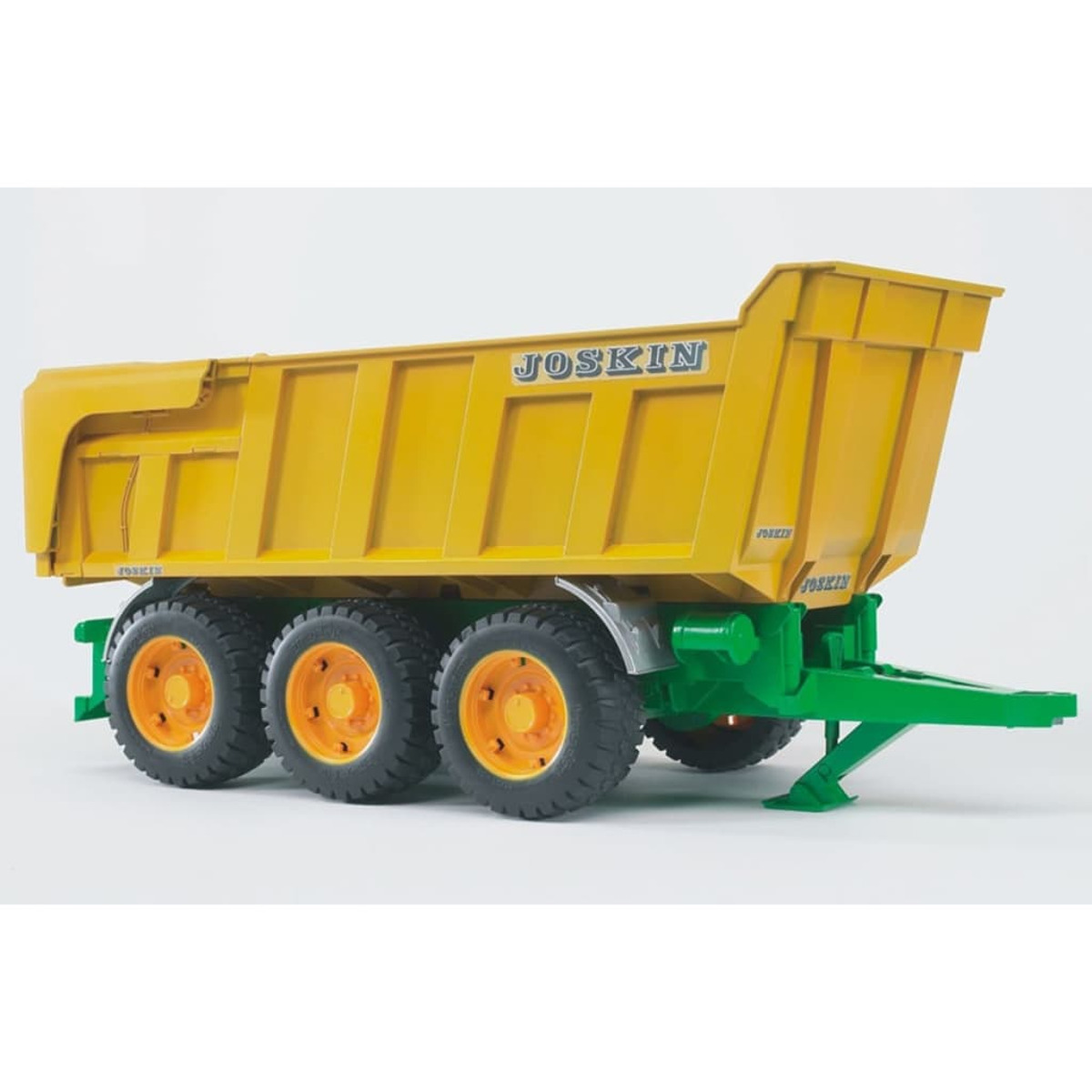 Un remolque amarillo Joskin sobre un chasis verde con ruedas grandes, sobre un fondo blanco.