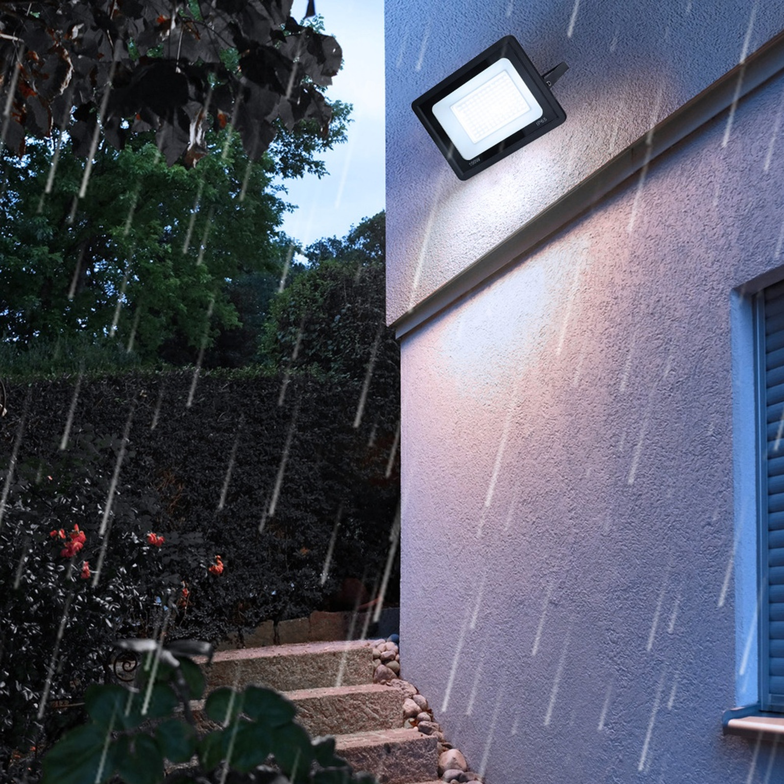 Un foco LED montado en una pared, iluminado en una escena lluviosa al aire libre.