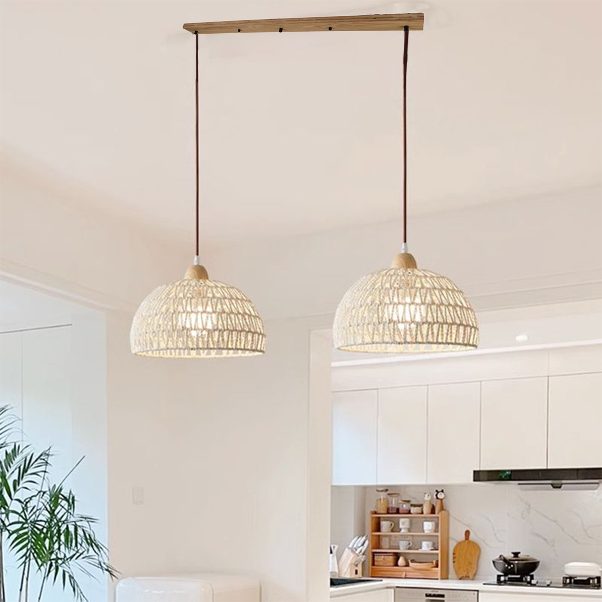 Dos lámparas colgantes tejidas cuelgan sobre una isla de cocina, suspendidas de una barra de madera en un entorno de cocina moderna.