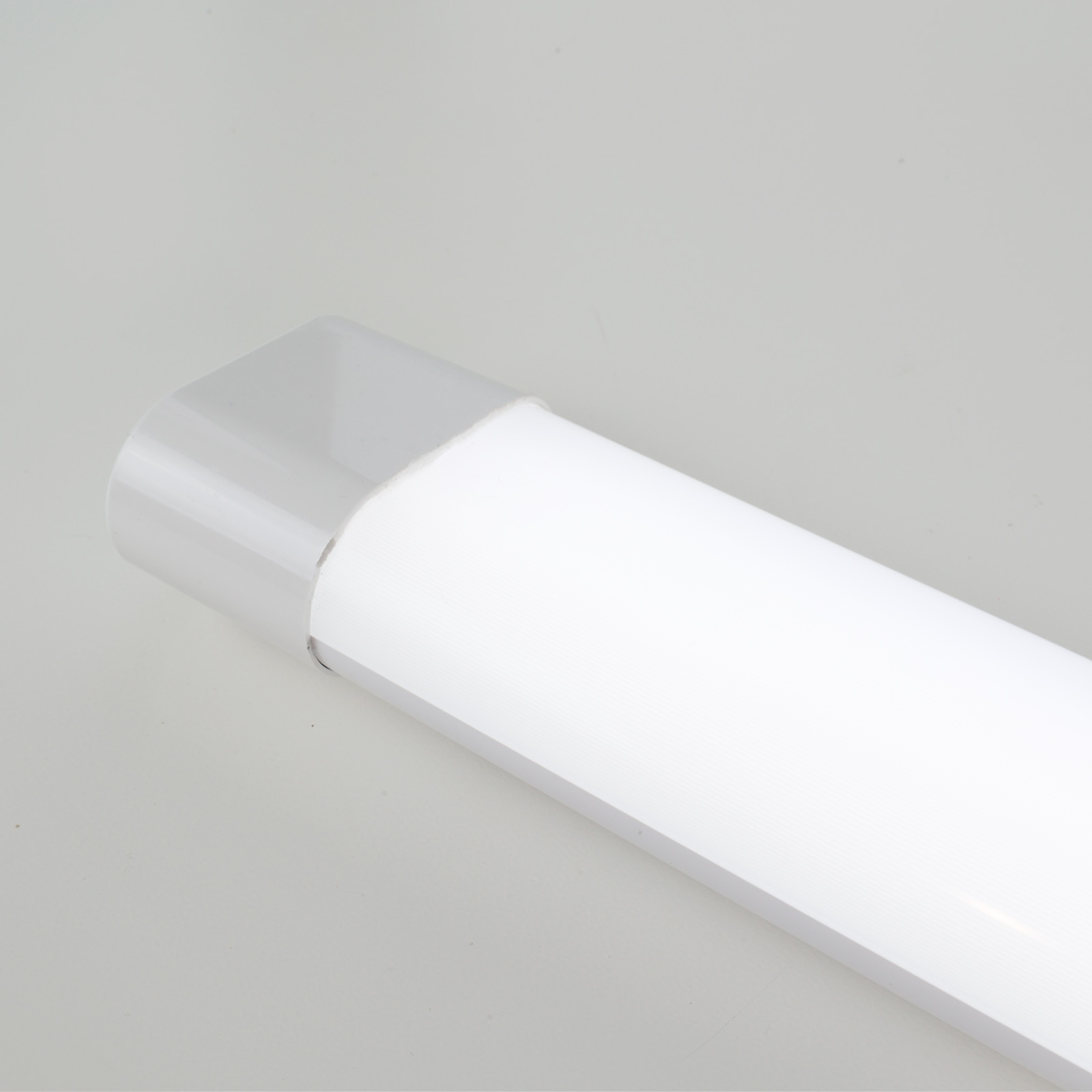 Una luminaria blanca y gris. Tiene forma de tubo largo y delgado.