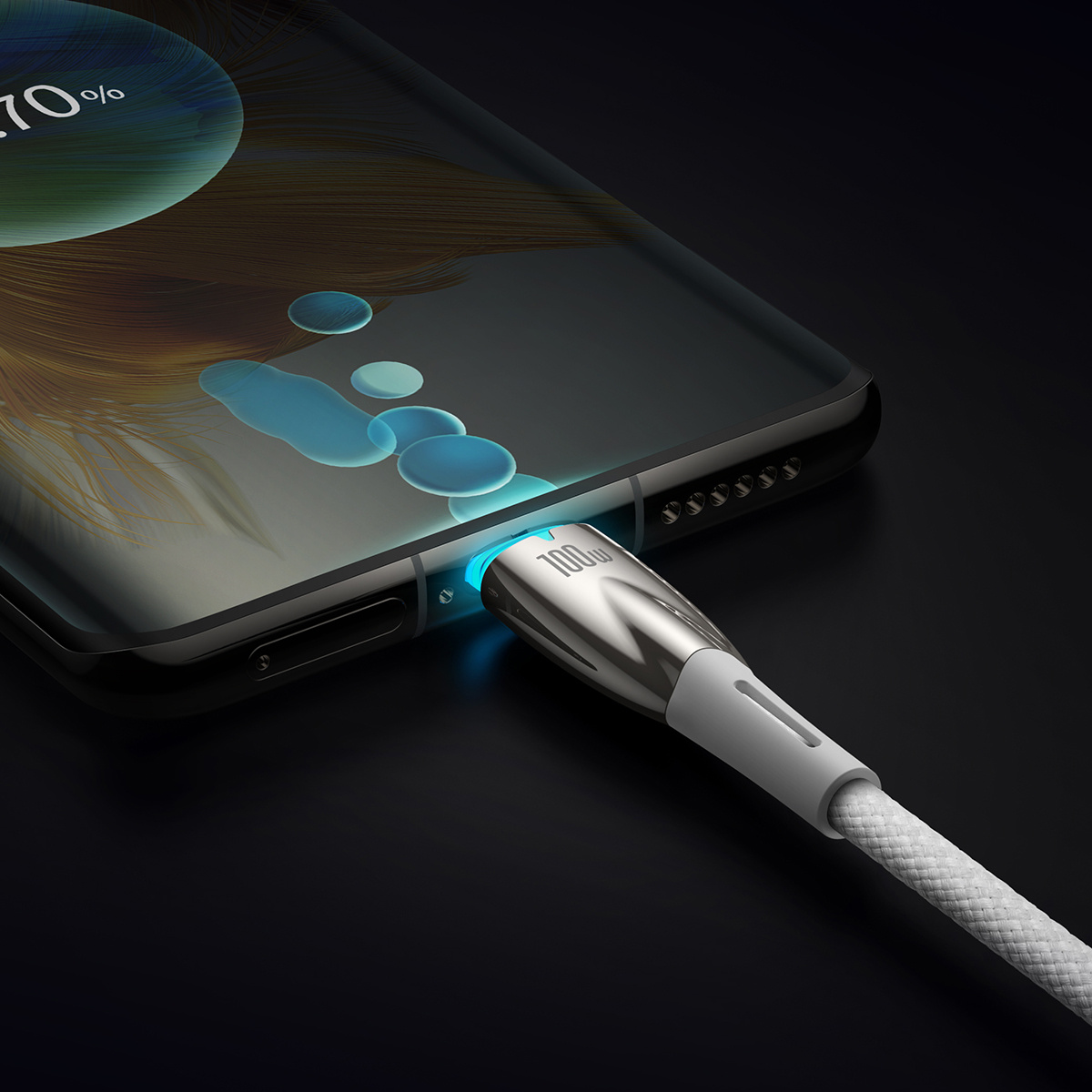 Telefon jest podłączony do ładowarki. Ładowarka jest srebrna z białym kablem. Telefon pokazuje stan ładowania.