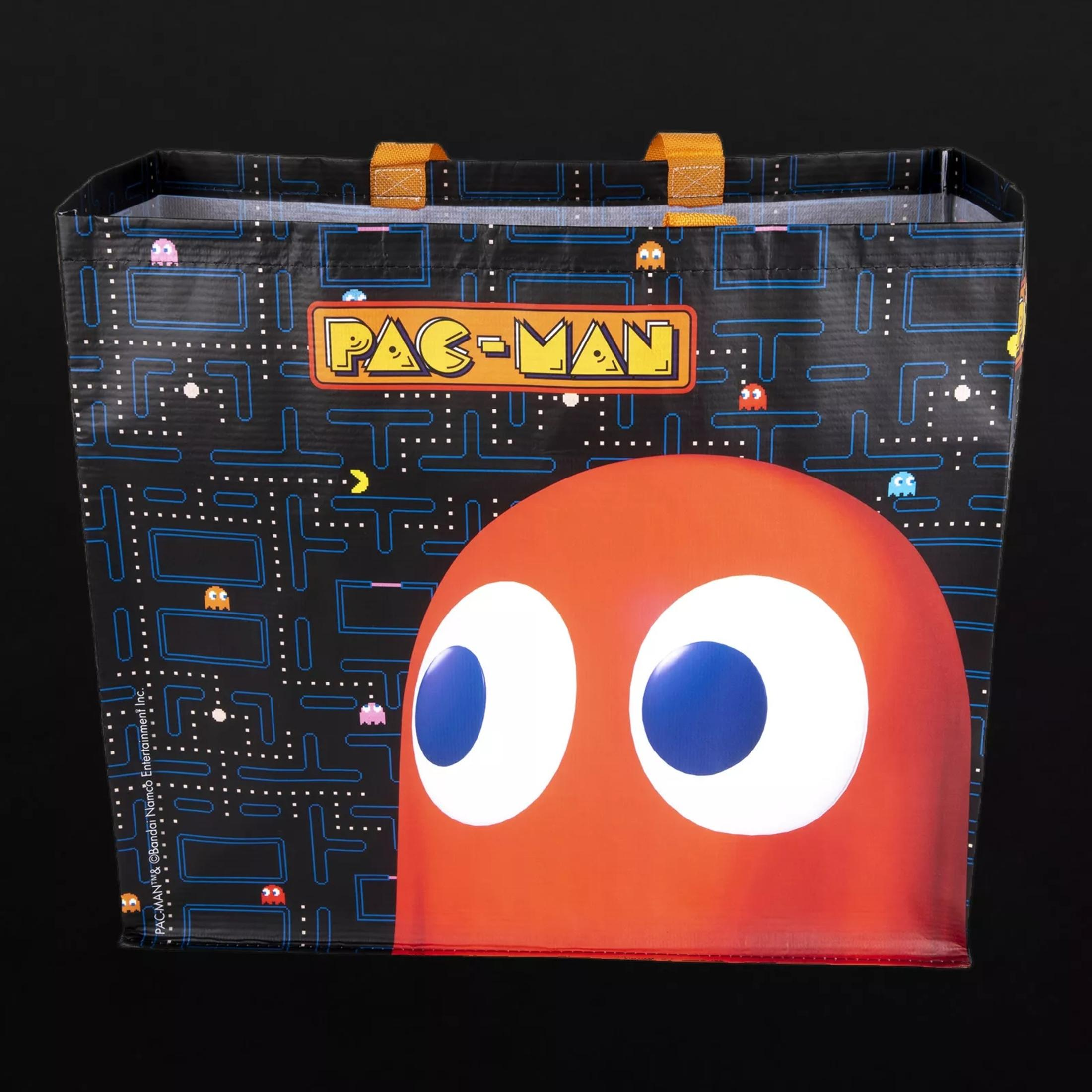Eine Pac-Man-Einkaufstasche auf einer schwarzen Oberfläche. Die Tasche hat Pac-Man auf der Vorderseite.