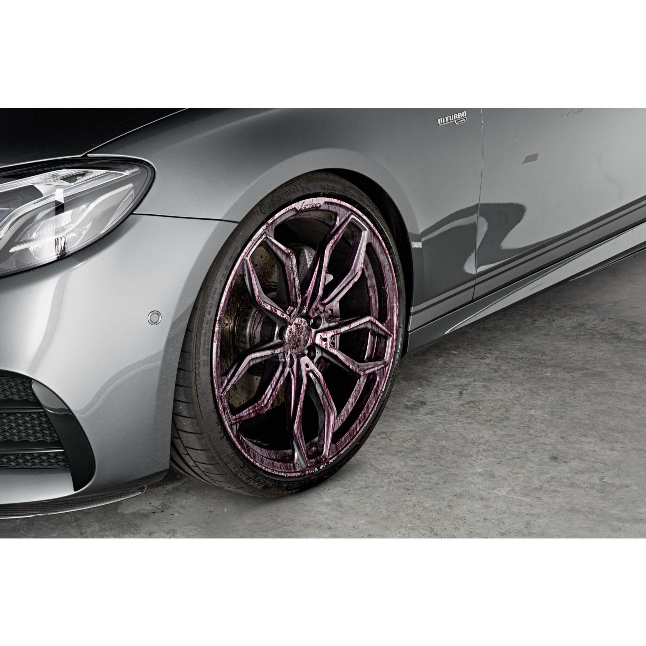 Nahaufnahme eines Autorads mit pink getönter Felge und Reifen. Die Karosserie des Autos ist grau.