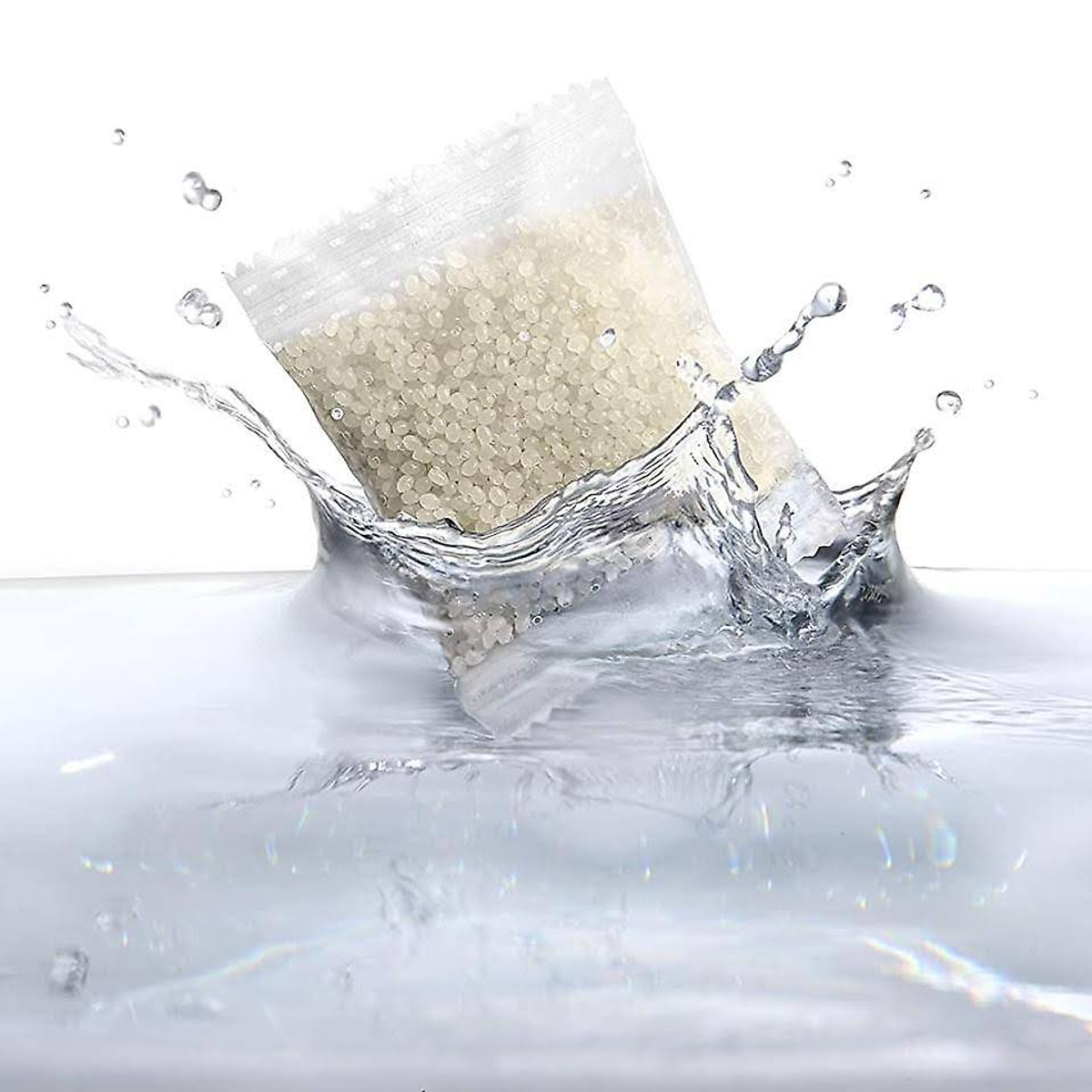 A transparent sachet of small, beige spheres splashing into water, creating a splash effect.