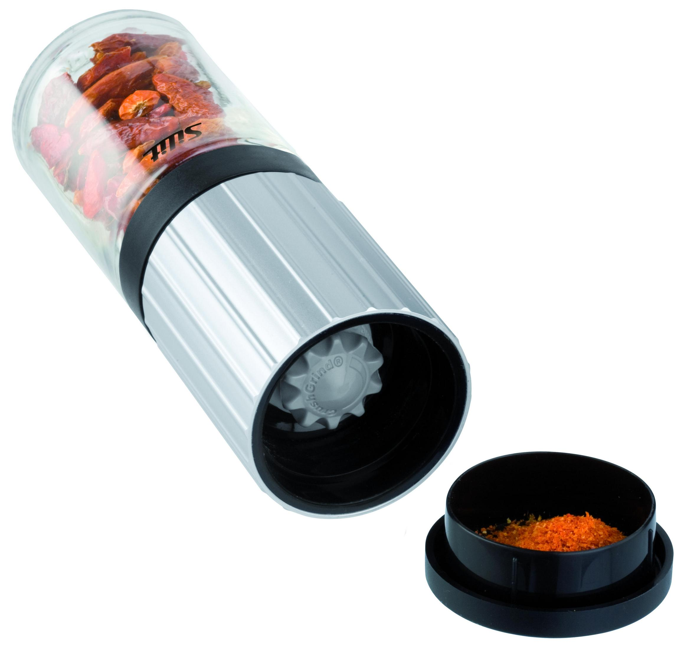 Eine Pfeffermühle mit roten Paprika, mit schwarzem Deckel und gemahlenem Pfeffer am Boden.