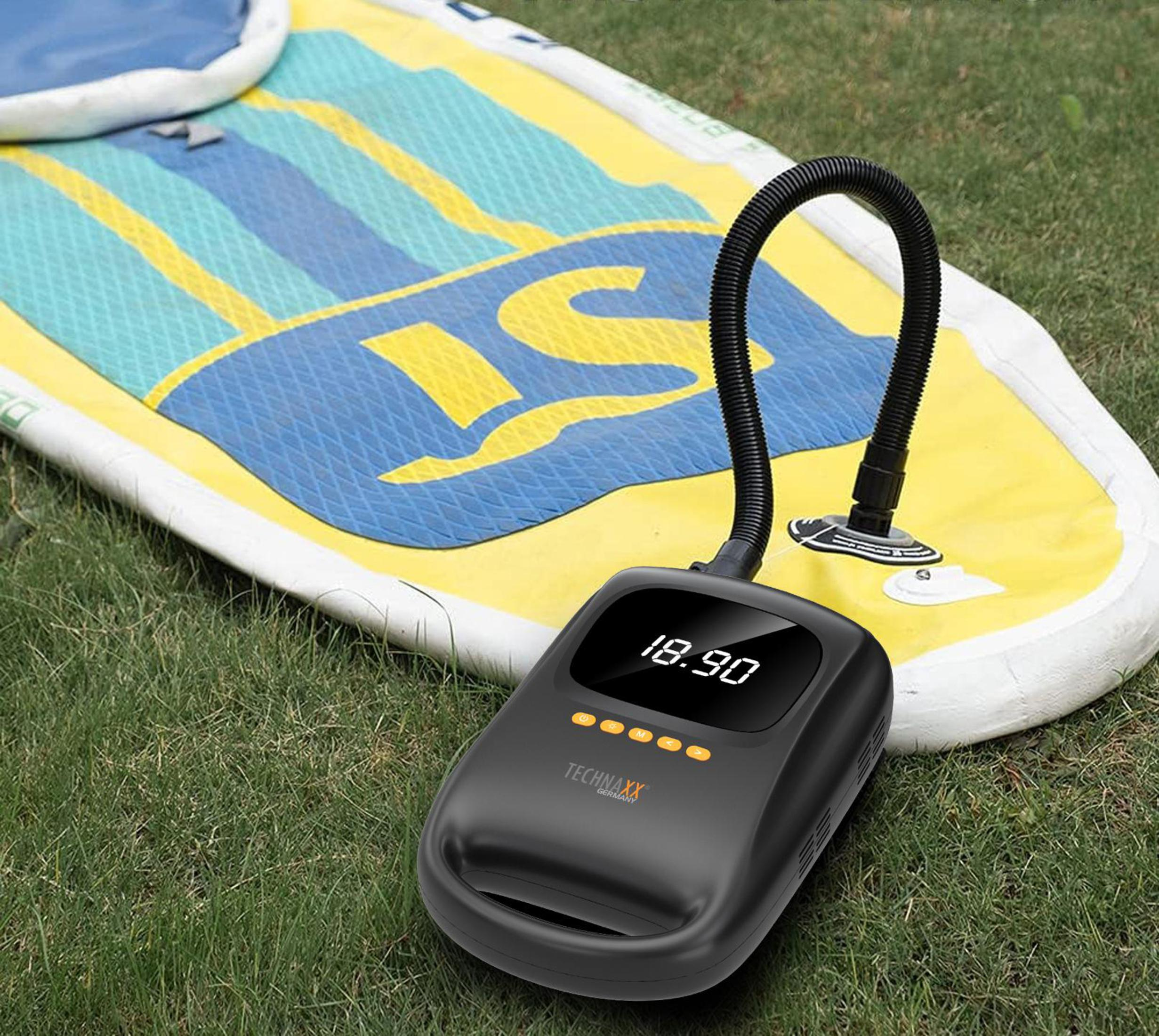 Eine schwarze Luftpumpe auf einem Paddleboard, die den Druck anzeigt: 18,90. Grünes Gras im Vordergrund.
