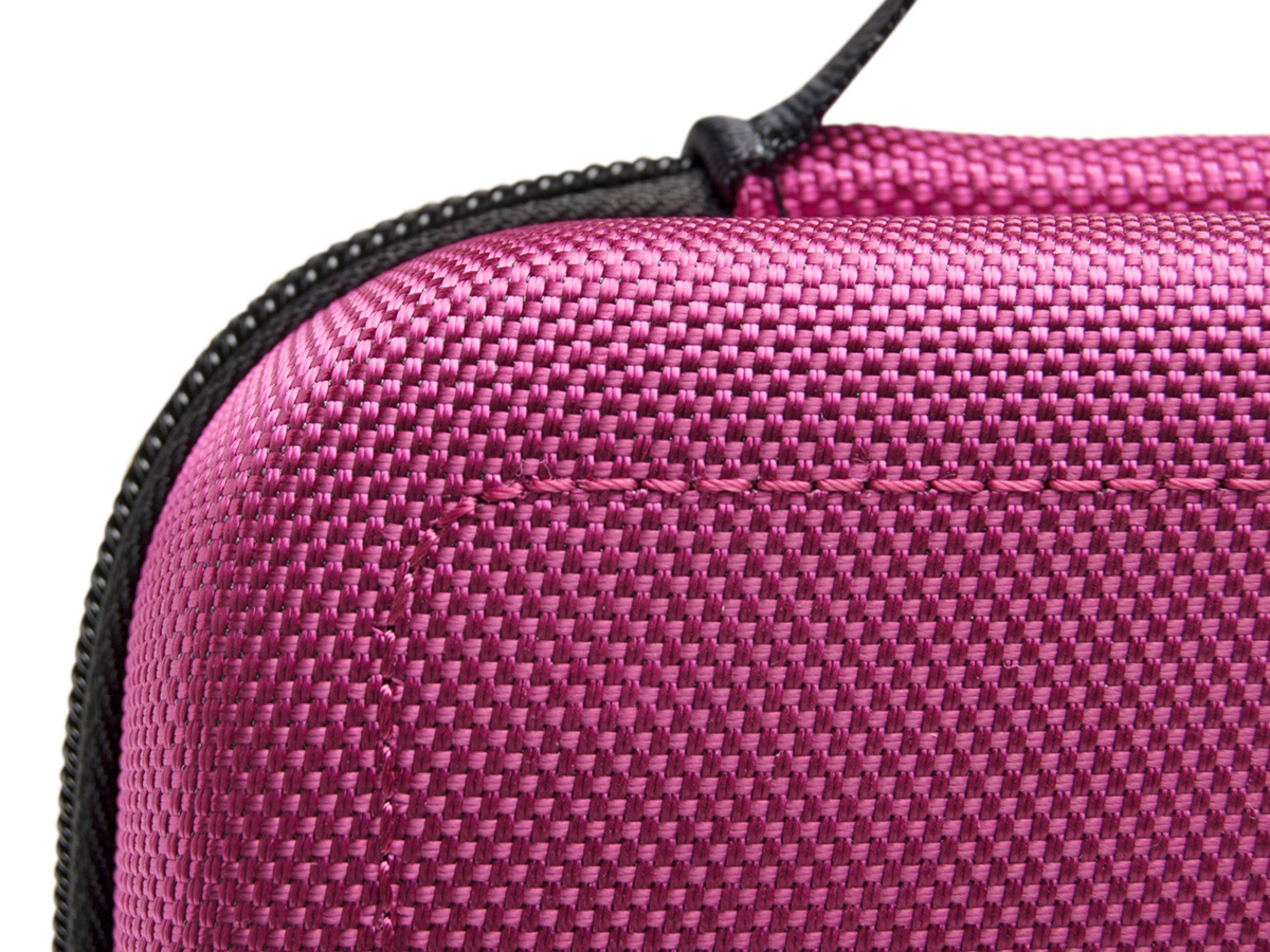 Nahaufnahme des rosa Stoffkoffers. Zeigt die Textur und den schwarzen Reißverschluss im Detail.