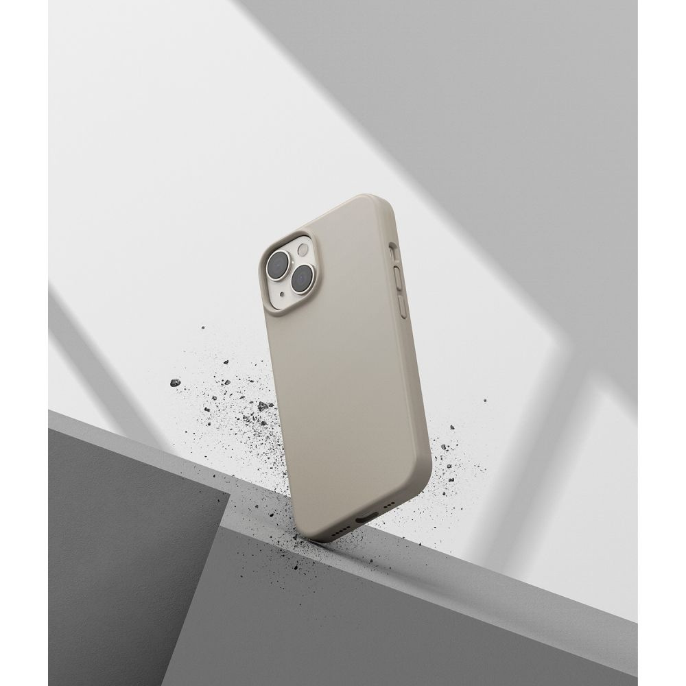 Etui na telefon leży na szarej, pochylonej powierzchni, z gruzem wokół niego.