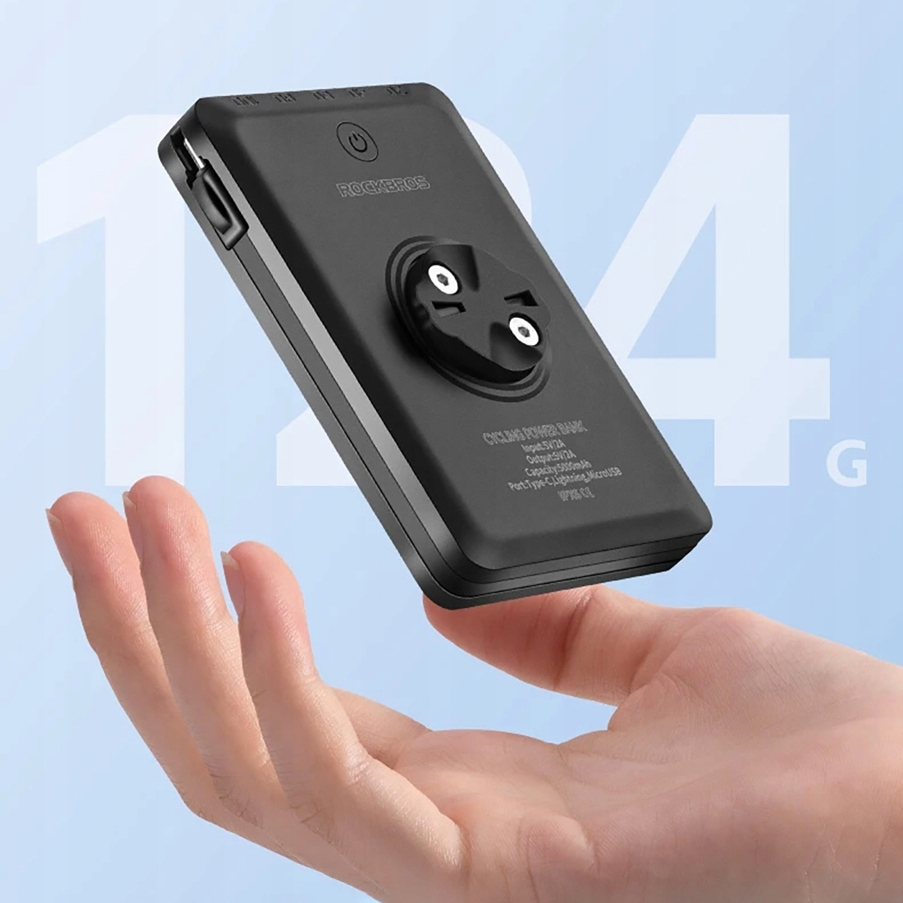 Dłoń trzymająca czarne urządzenie ze światłem. Urządzenie ma uchwyt i port USB. Jasnoniebieskie tło.