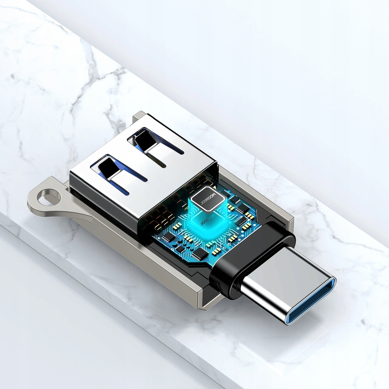 Srebrny adapter USB-C z niebieskim portem USB, płytką drukowaną i marką 'JOYROOM' na białym tle.