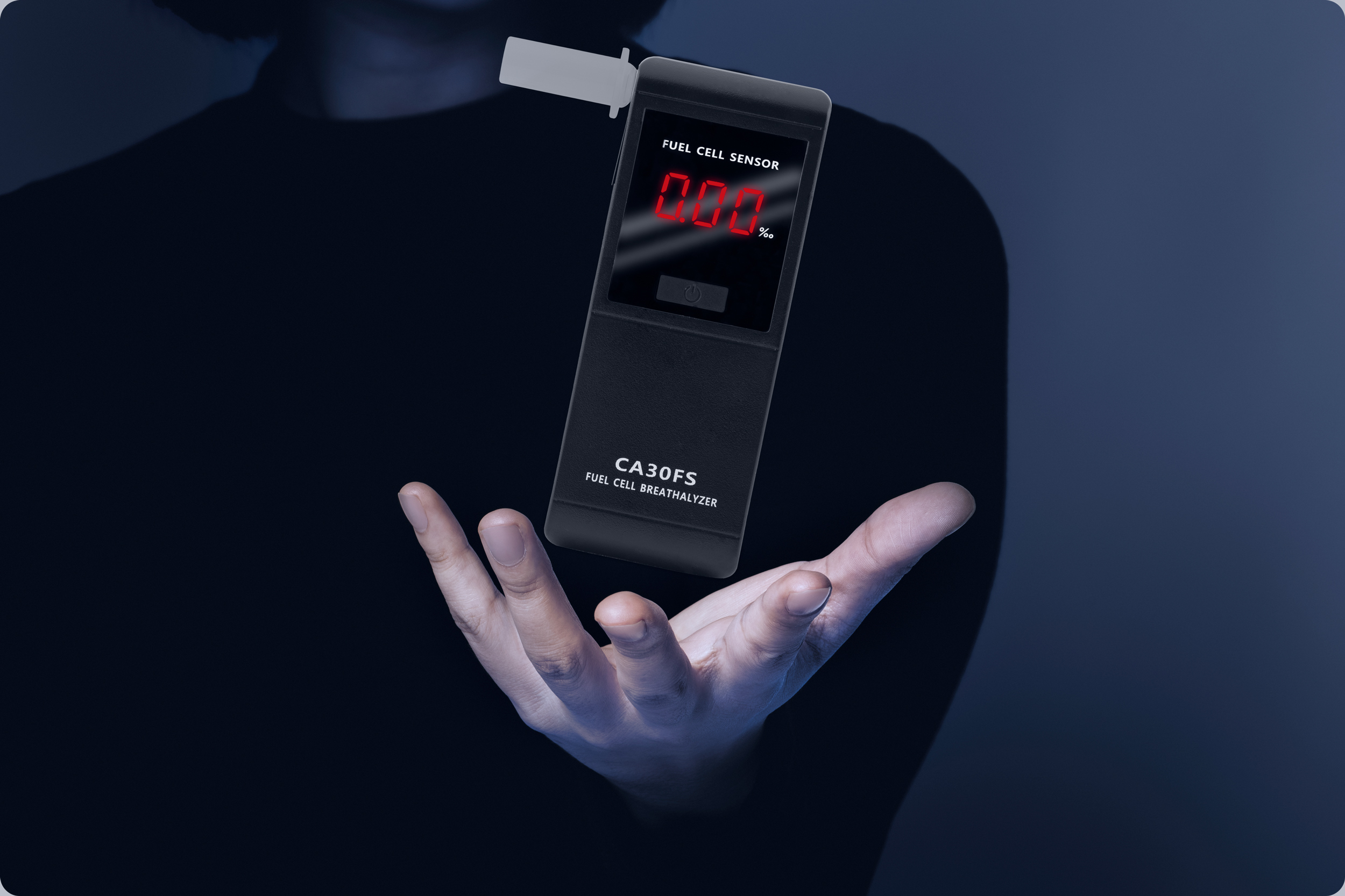 Ręka trzyma alkomat, pokazując 0,00%. Ciemne tło, urządzenie unosi się.