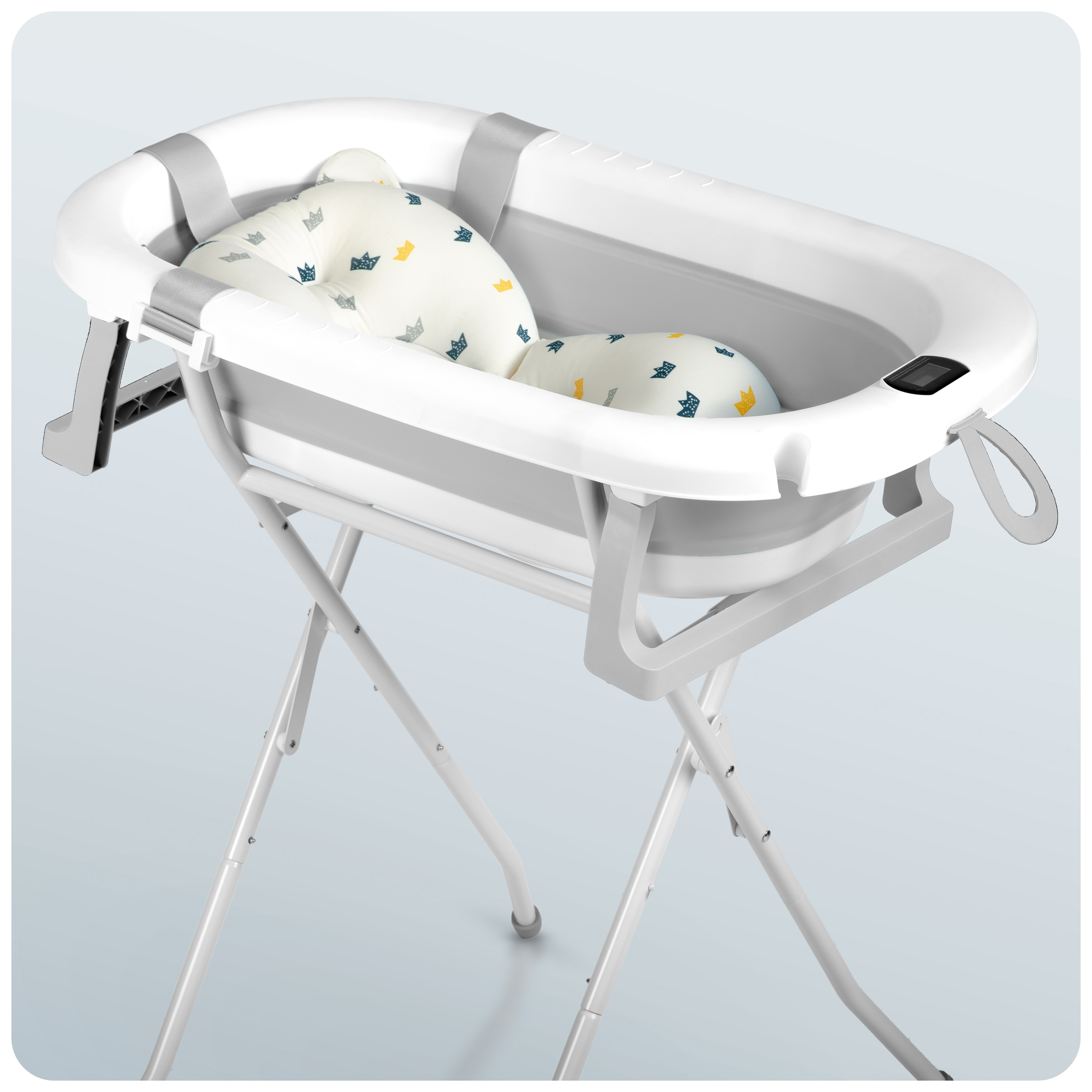 Biała i szara wanienka dla dziecka z poduszką dla dziecka, umieszczona na białym stojaku.