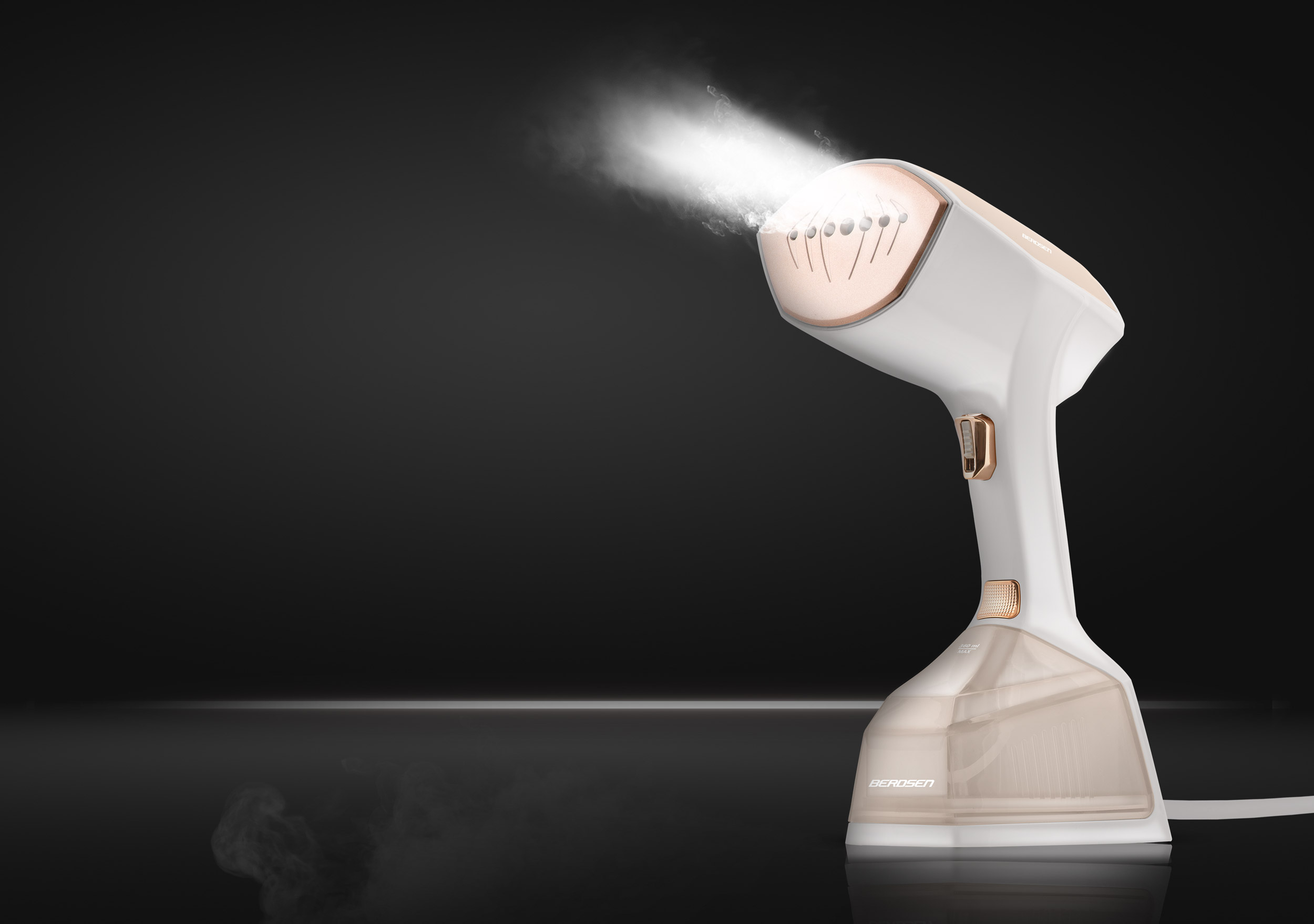 Ręczny parownik do ubrań emitujący parę. Biały i beżowy, akcenty w kolorze różowego złota. Ciemne tło.