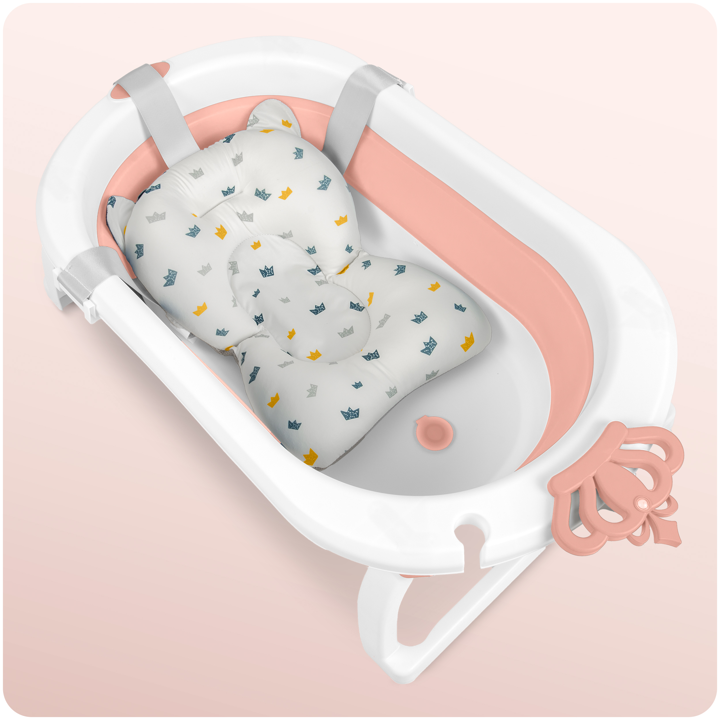 Wanienka dla niemowląt z poduszką do kąpieli. Jest różowa i biała. Poduszka do kąpieli ma wzór korony.