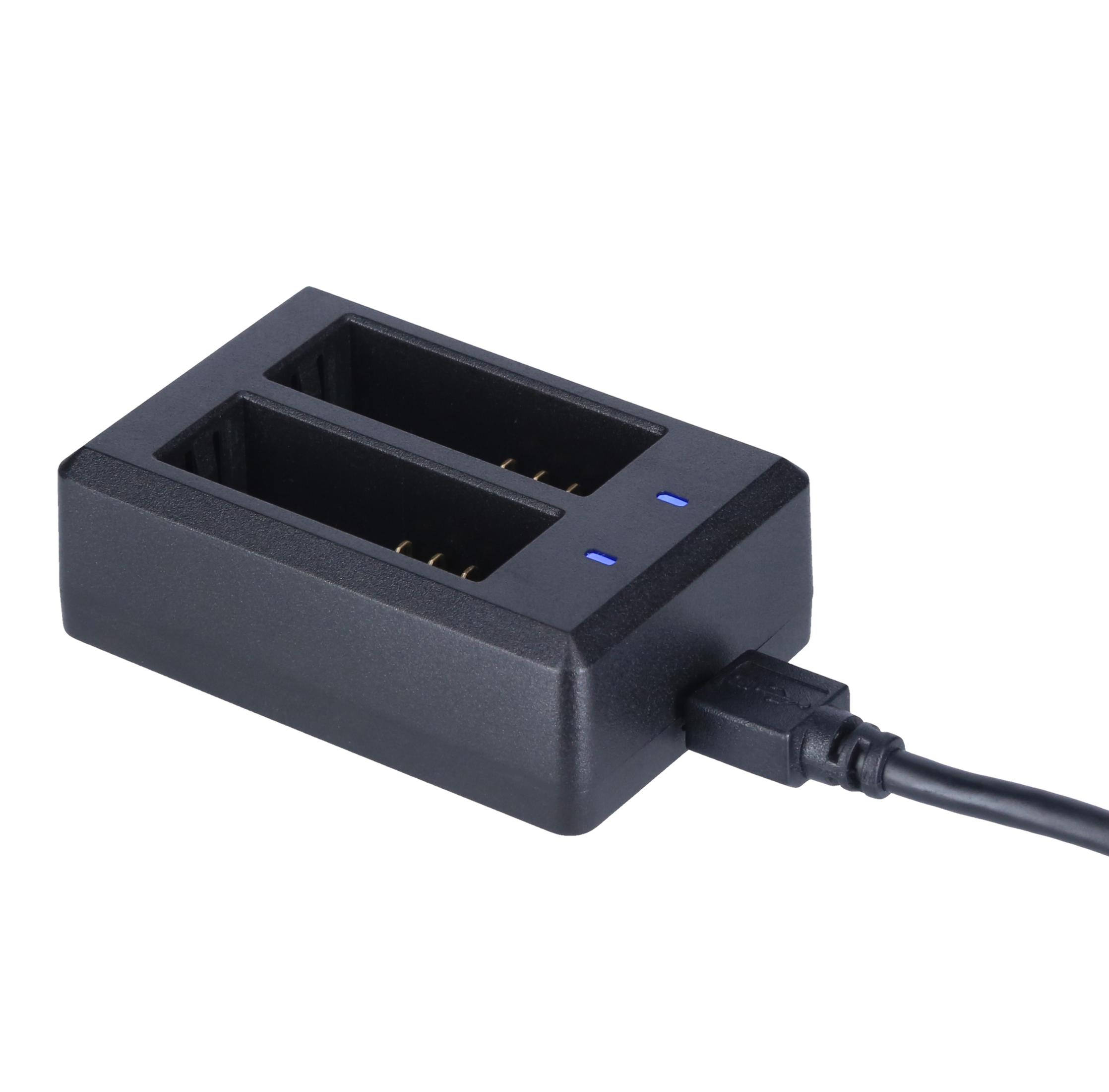 Ein schwarzes Batterieladegerät mit zwei leeren Steckplätzen. Ein USB-Kabel ist angeschlossen. Blaue Lichter leuchten.