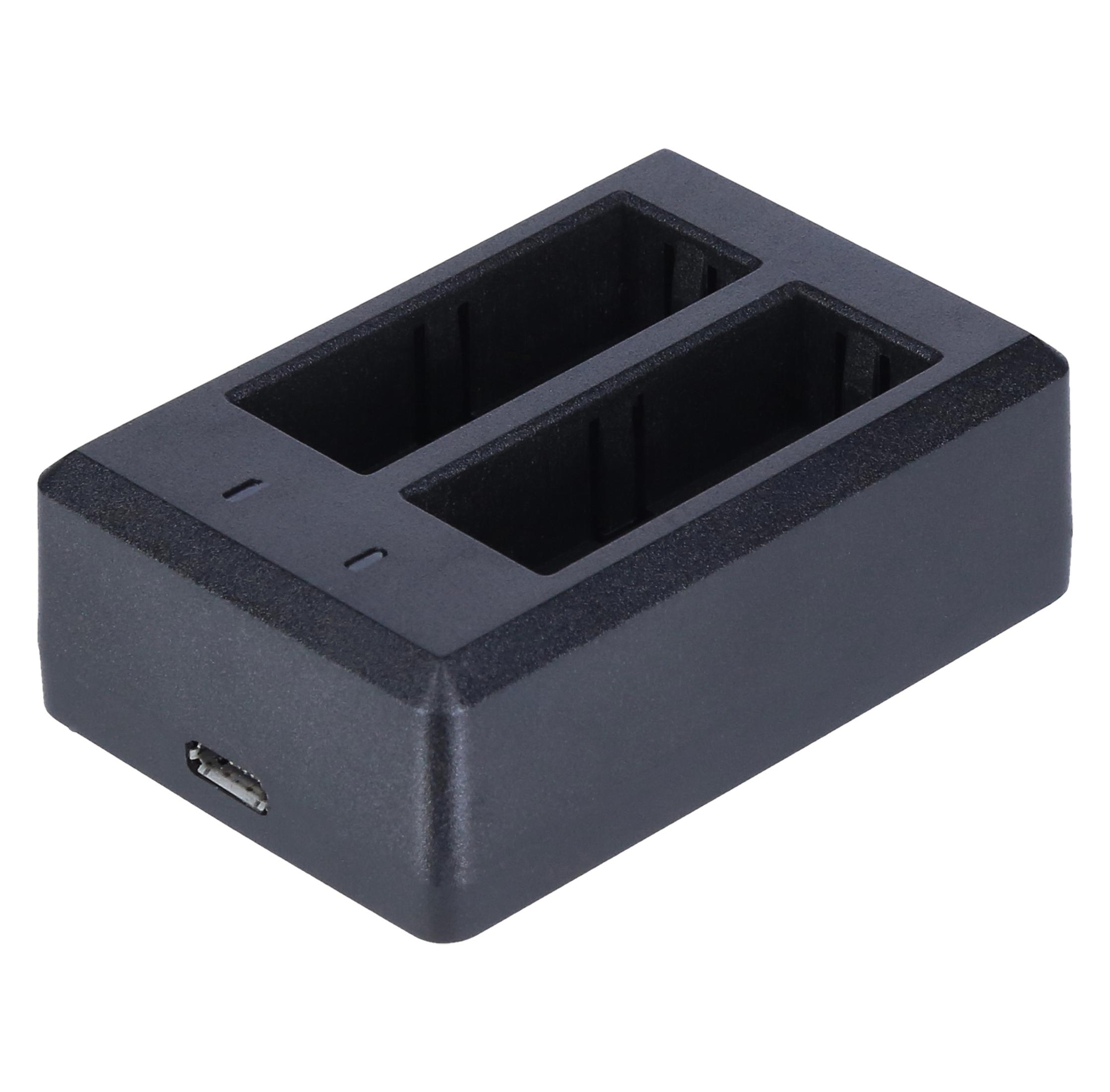 Ein schwarzes Batterieladegerät mit zwei leeren Steckplätzen. Kein USB-Kabel angeschlossen.