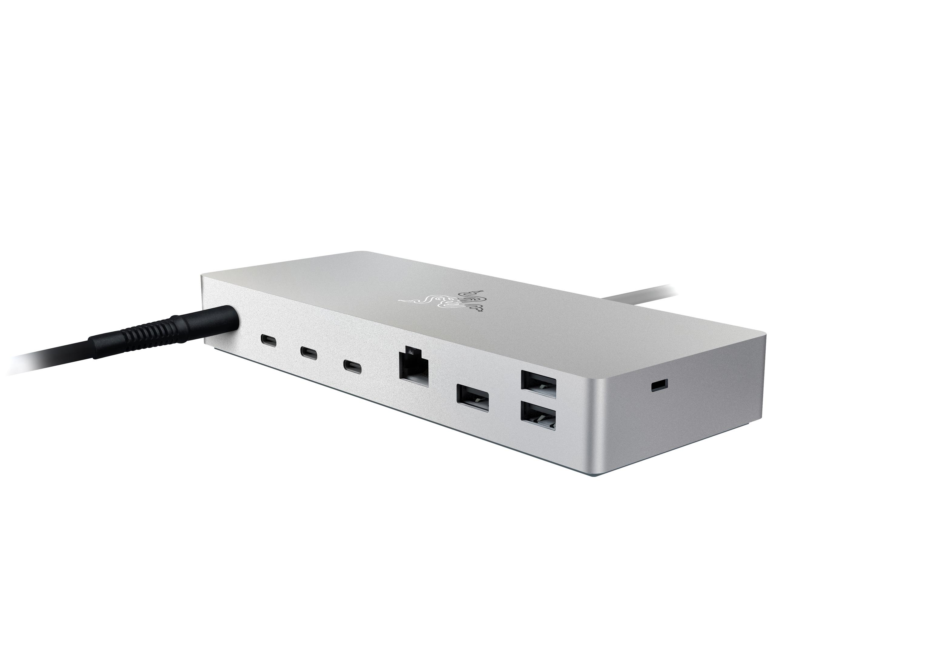 Eine silberne Razer-Dockingstation mit Anschlüssen. Ein schwarzes Kabel ist eingesteckt. Schwarze Anschlüsse sind sichtbar.