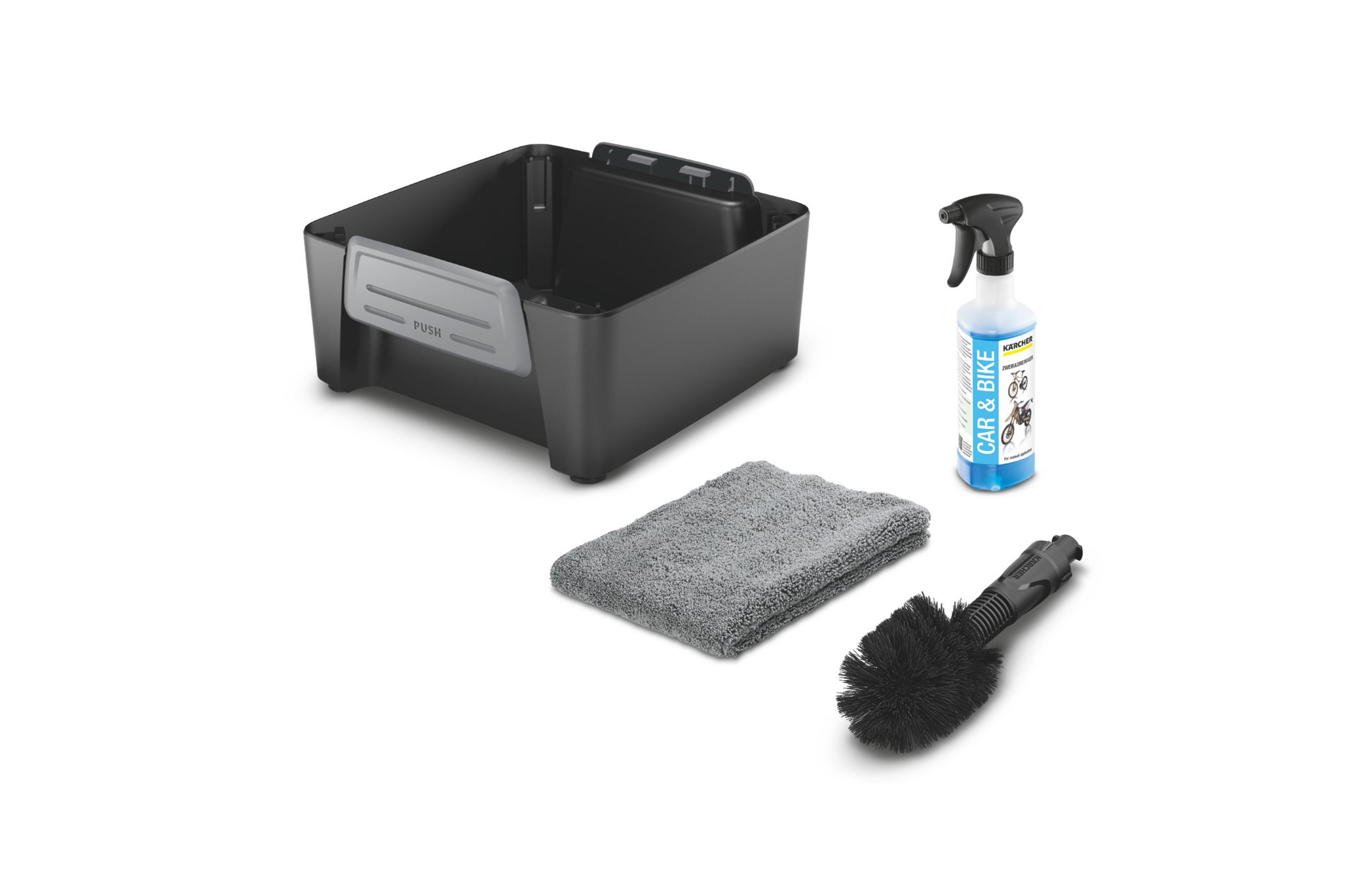 Un kit di pulizia nero con flacone spray, panno, spazzola e un contenitore. Sfondo bianco.