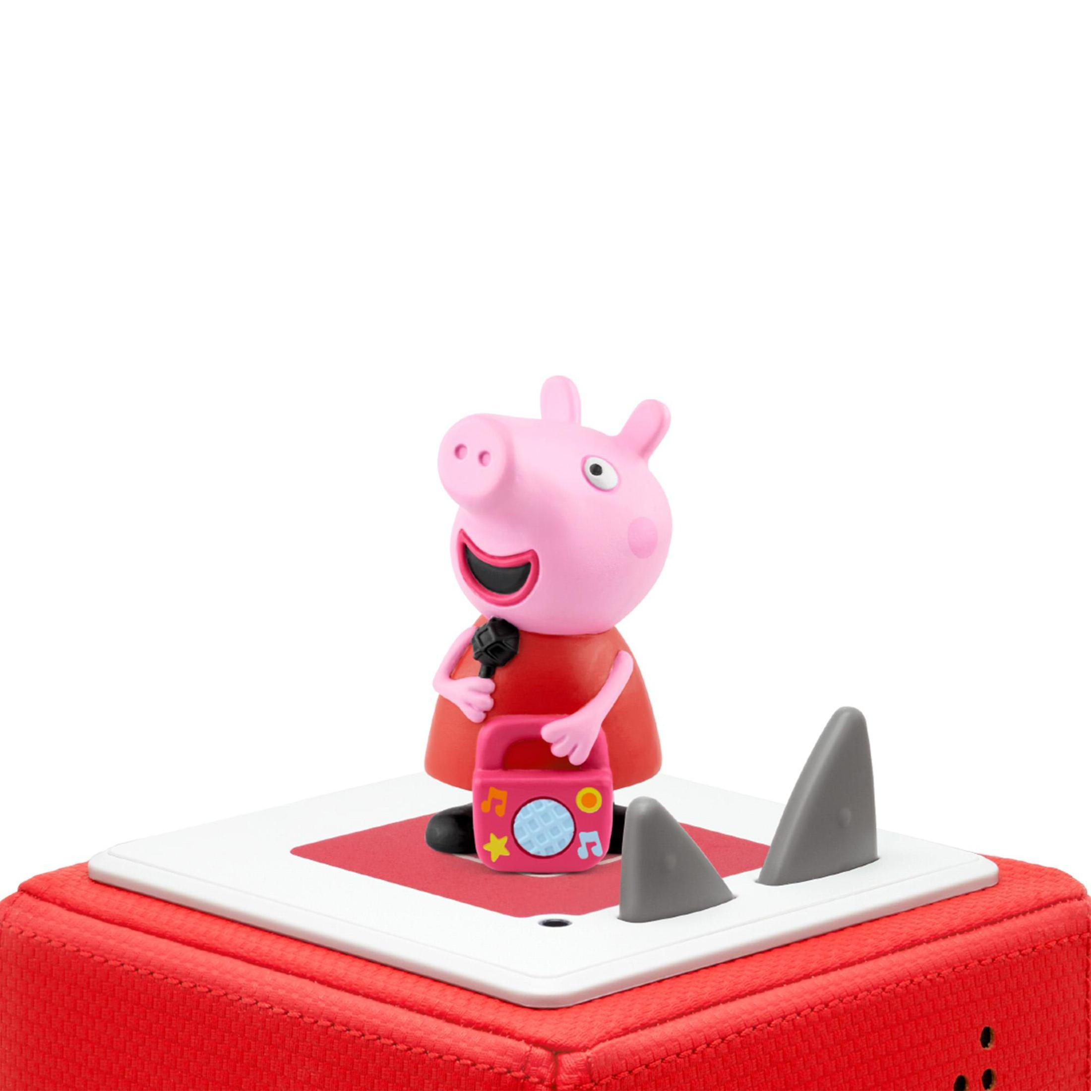 Peppa Wutz Figur mit Mikrofon und Radio. Die Figur steht auf einem roten Sockel mit Haifischflossen.