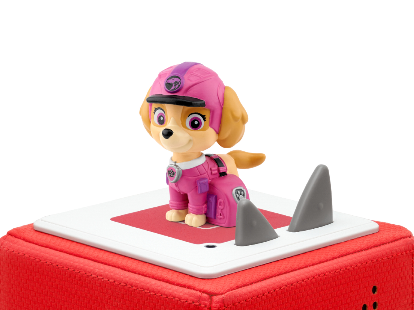 Eine pinke Paw Patrol Skye Figur auf roter Basis mit Haifischflossen.