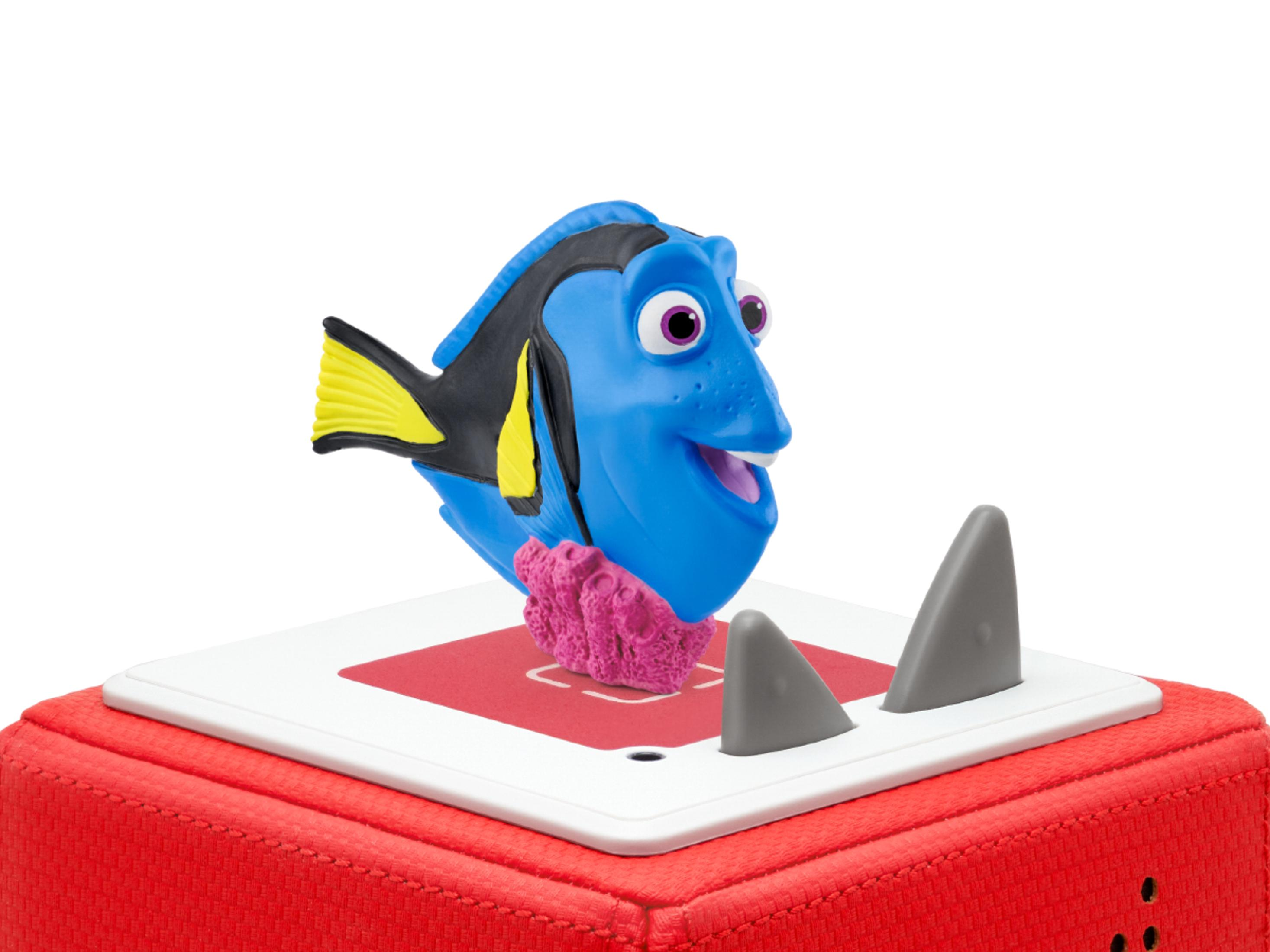 Ein blaues Fischspielzeug mit Dorys Merkmalen sitzt auf einem roten Sockel mit grauen Haifischflossen.