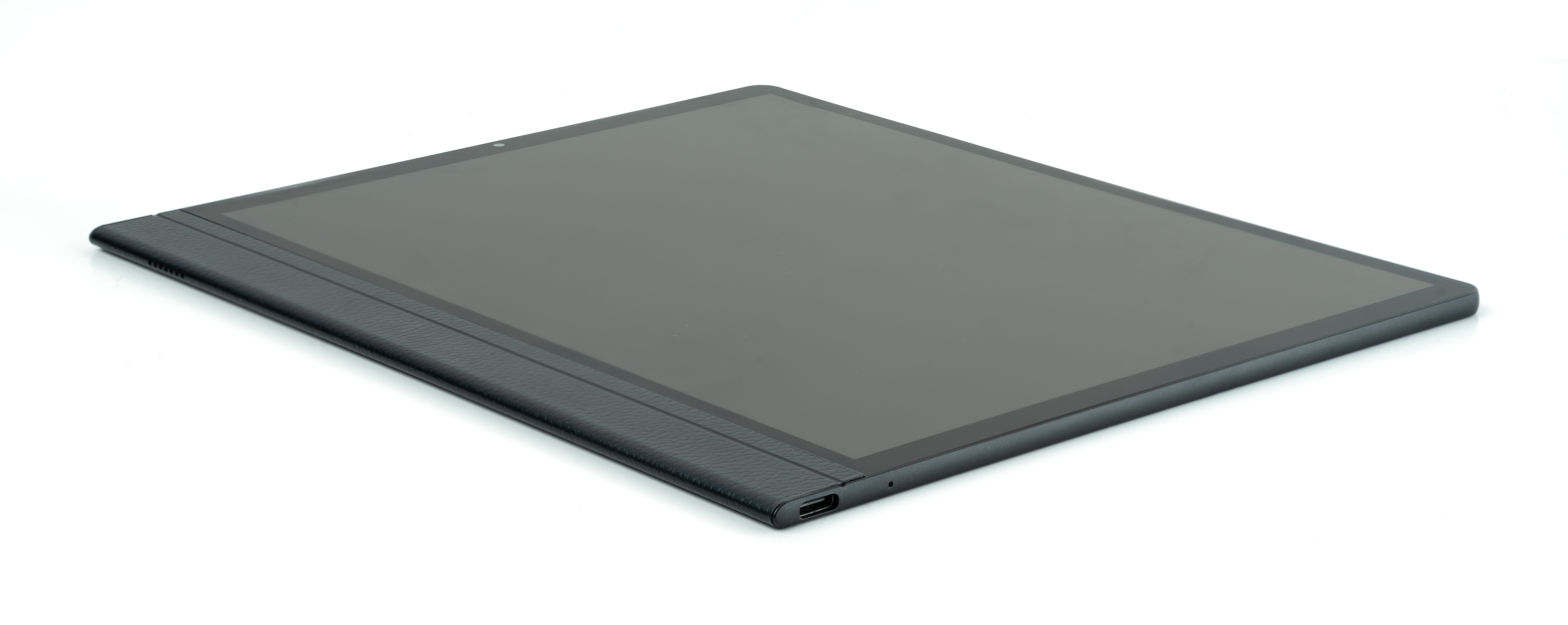 Un tablet nero su una superficie bianca, con una vista laterale che mostra un bordo strutturato e una porta di ricarica.