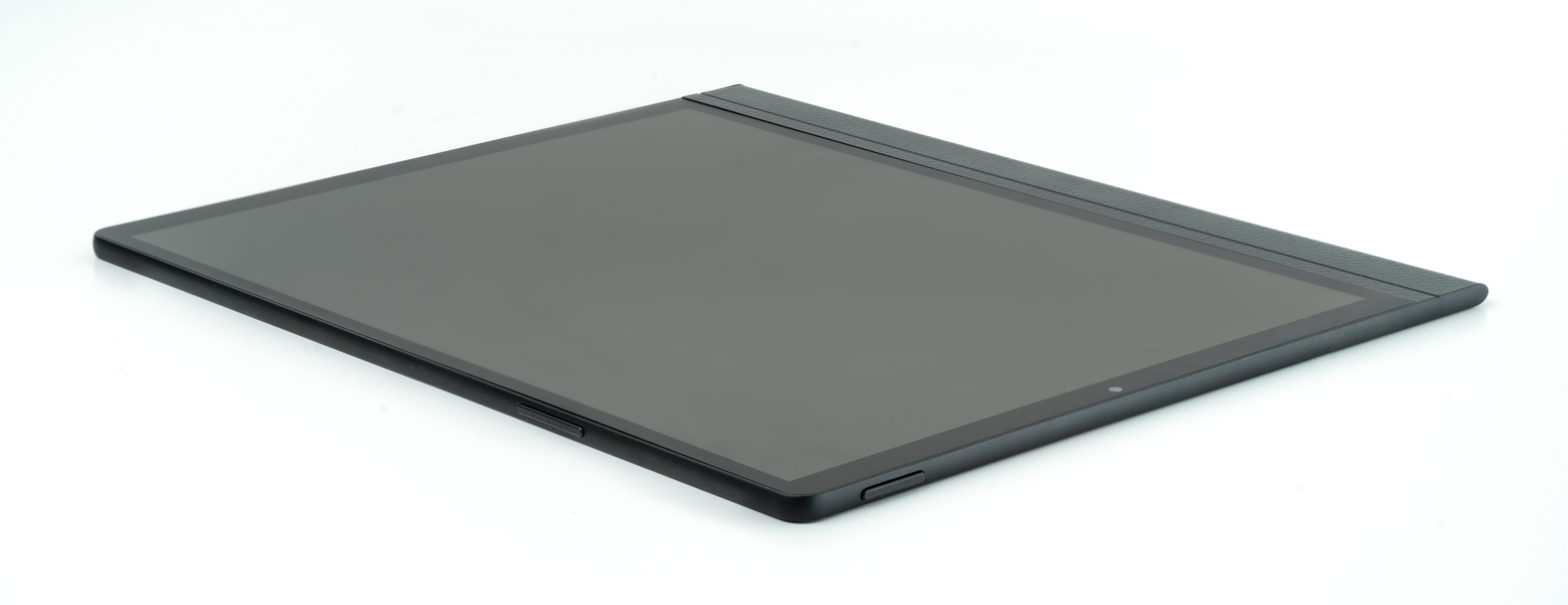 Un tablet nero su una superficie bianca, vista laterale che mostra un bordo strutturato e il pulsante di accensione.