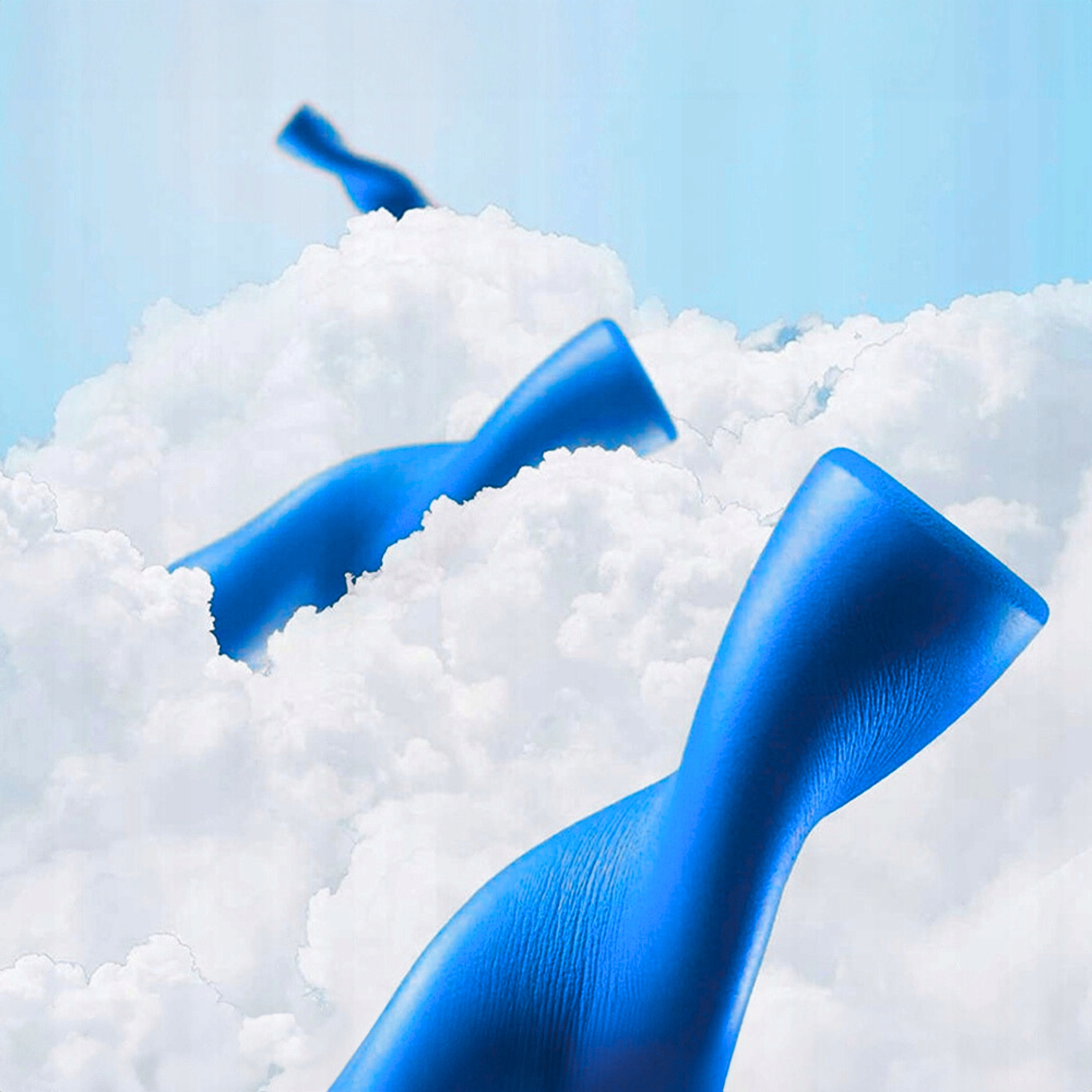 Trzy niebieskie kształty, przypominające części roweru, unoszą się przed puszystymi białymi chmurami.