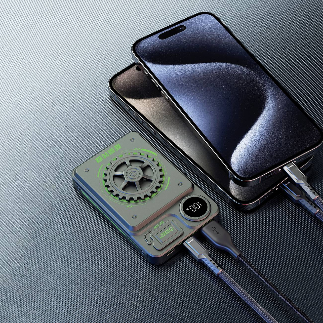 Dwa telefony ładujące się z power banku. Power bank szary z zielonym akcentem.