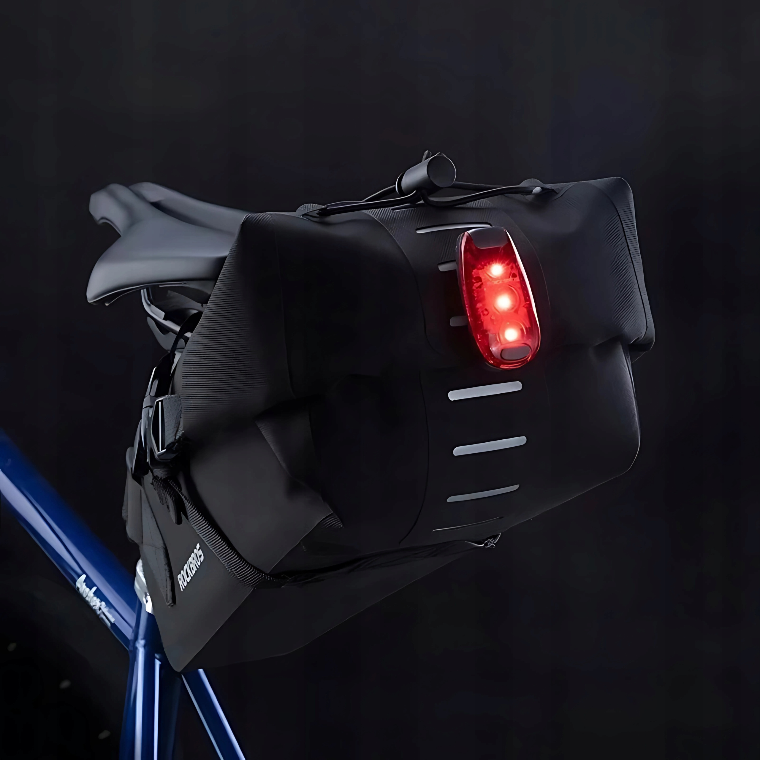 Czarna torba rowerowa Rockbros z czerwonym światłem przymocowanym do tyłu roweru.