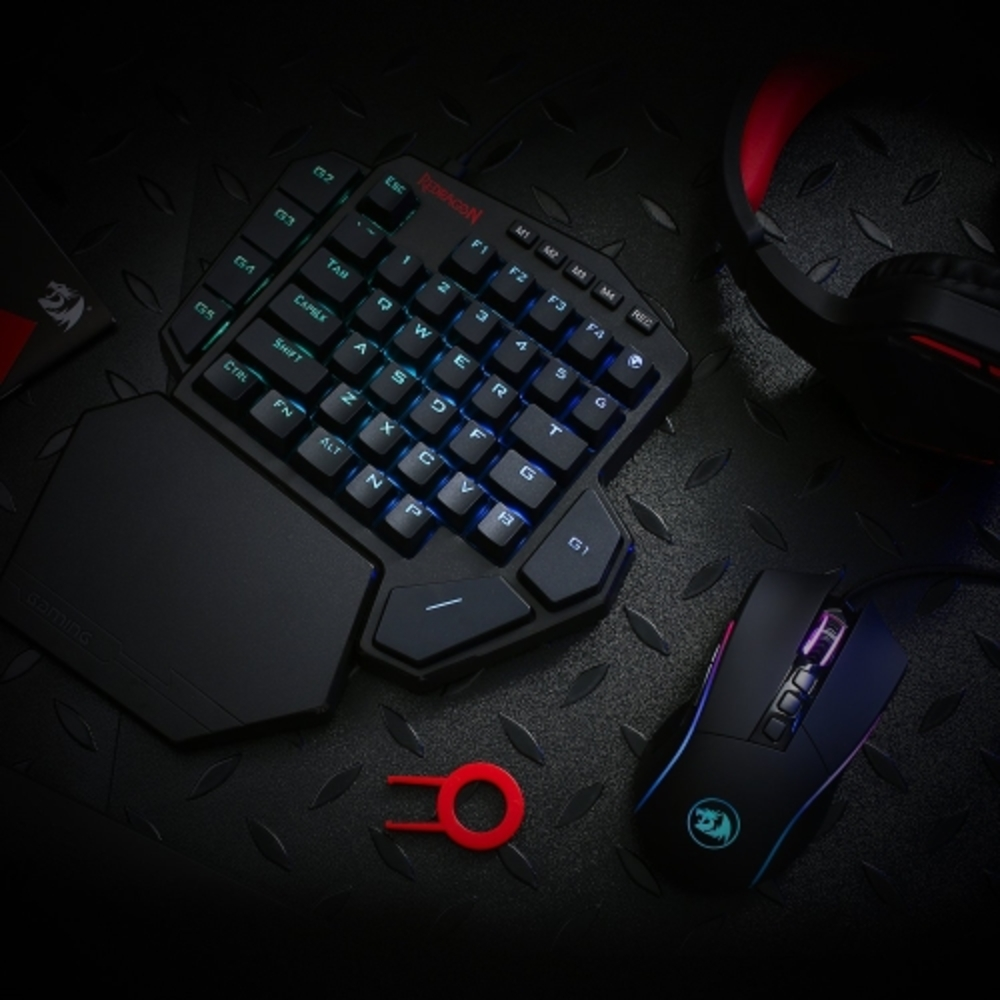 Tastiera da gioco, mouse e accessori su superficie strutturata. Tasti illuminati.