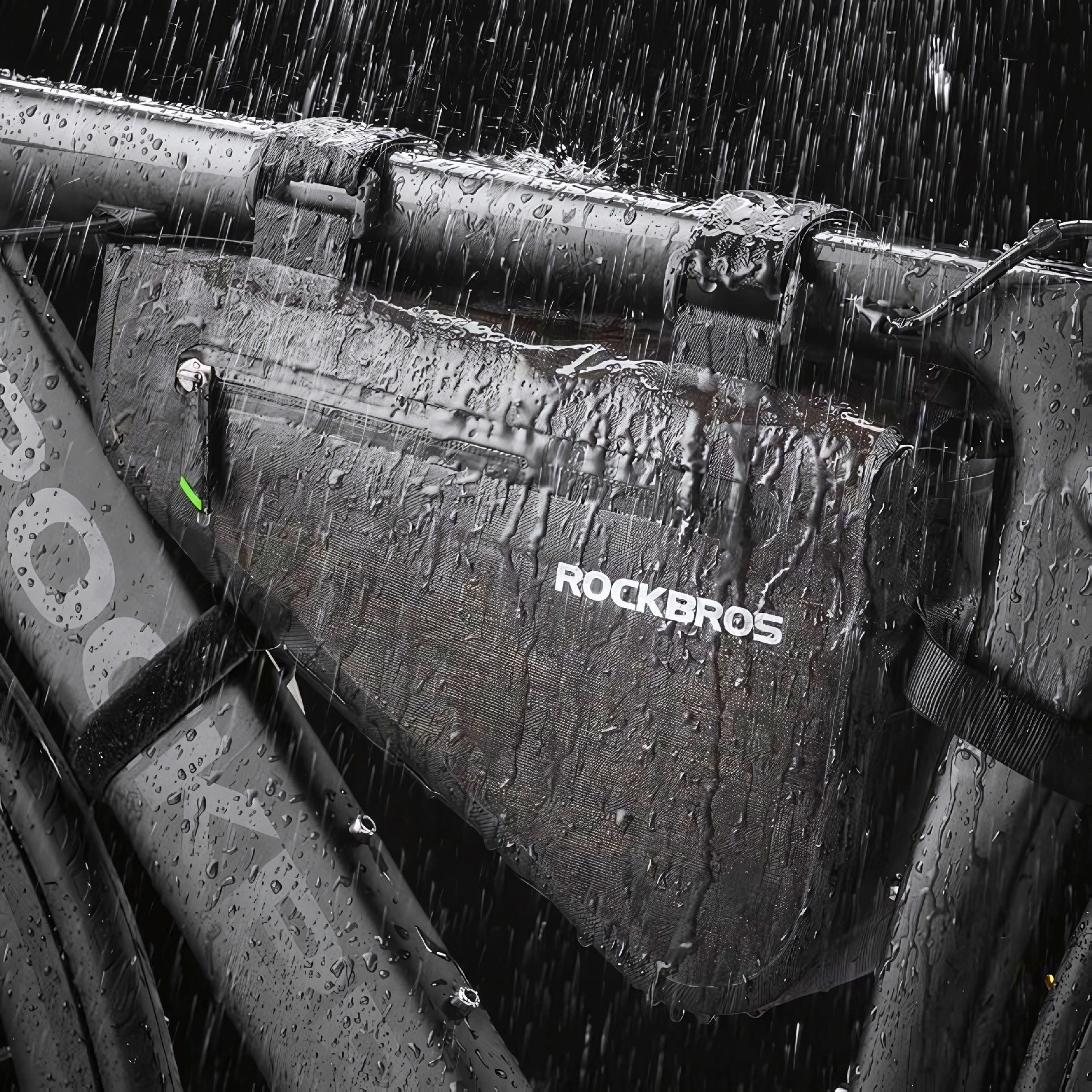 Czarna torba na ramę roweru zamontowana na rowerze w deszczu, z widocznym logo Rockbros.