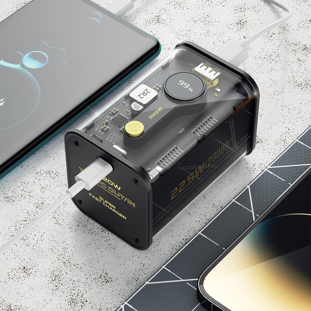 Power bank ładujący dwa telefony. Bank pokazuje 99% i jest podłączony do telefonów białym kablem.