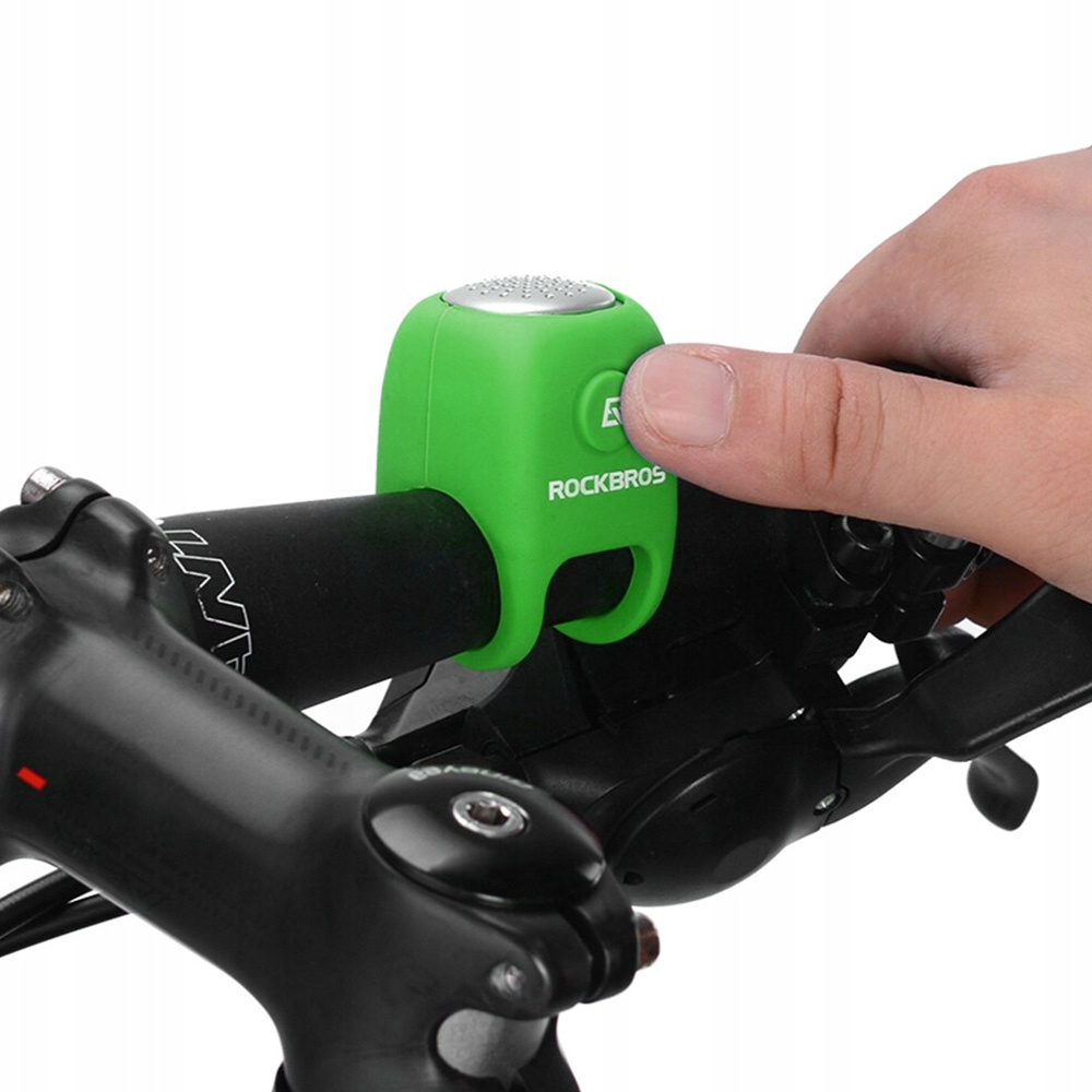 Dłoń naciskająca przycisk zielonego dzwonka rowerowego RockBros przymocowanego do kierownicy roweru.