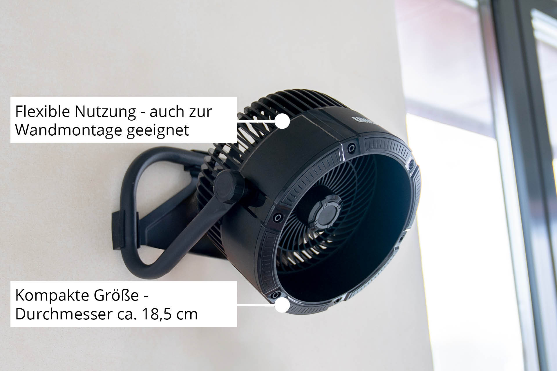 Ein kleiner schwarzer Ventilator ist an einer weißen Wand montiert. Der Text hebt seine Flexibilität hervor.