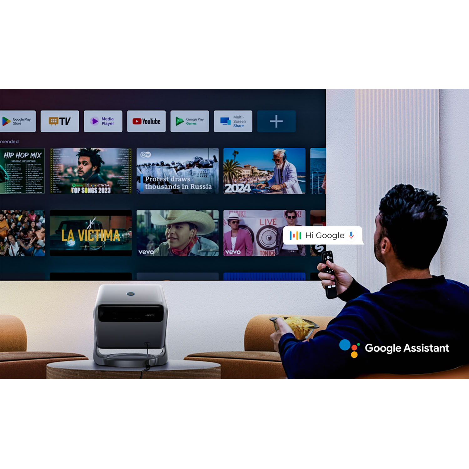 Mężczyzna używa pilota na kanapie, oglądając różnorodne treści na telewizorze Smart TV.