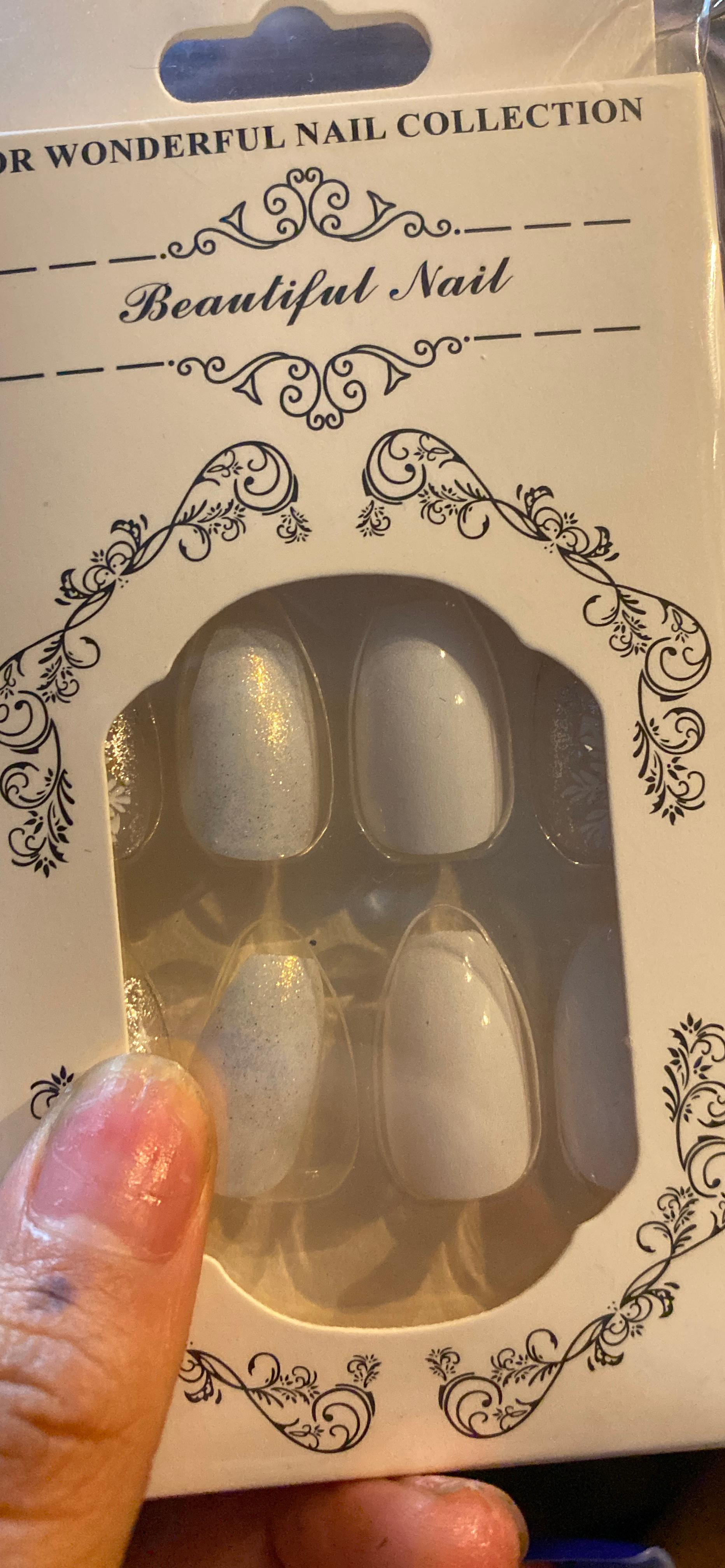 Eine Packung weißer Kunstnägel. Die Nägel sind in einer Schachtel mit der Aufschrift 'Beautiful Nail'.
