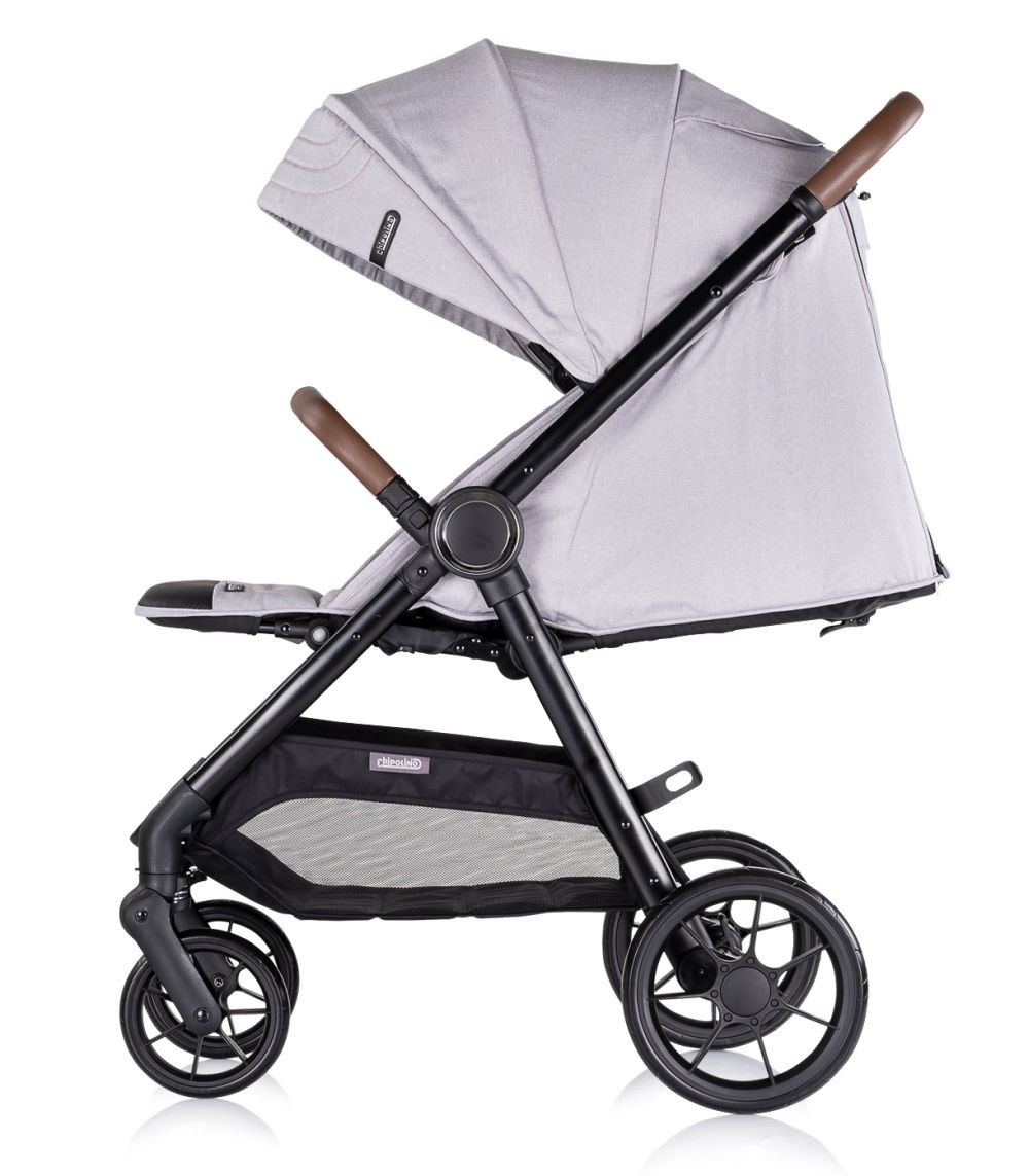 Ein hellgrauer Kinderwagen mit Verdeck und braunen Griffen vor weißem Hintergrund. Seitenansicht des Kinderwagens.