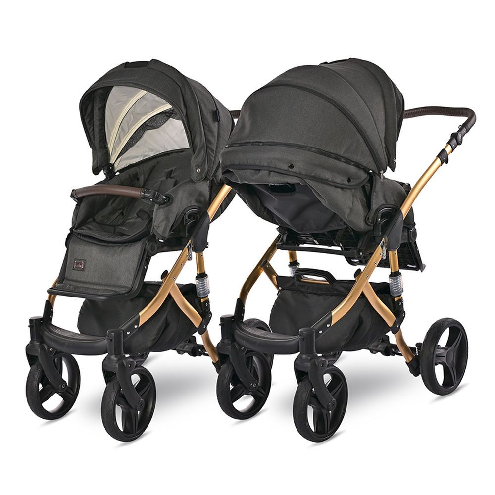 Zwei schwarze und goldene Kinderwagen nebeneinander. Jeder hat ein Verdeck und drei Räder.