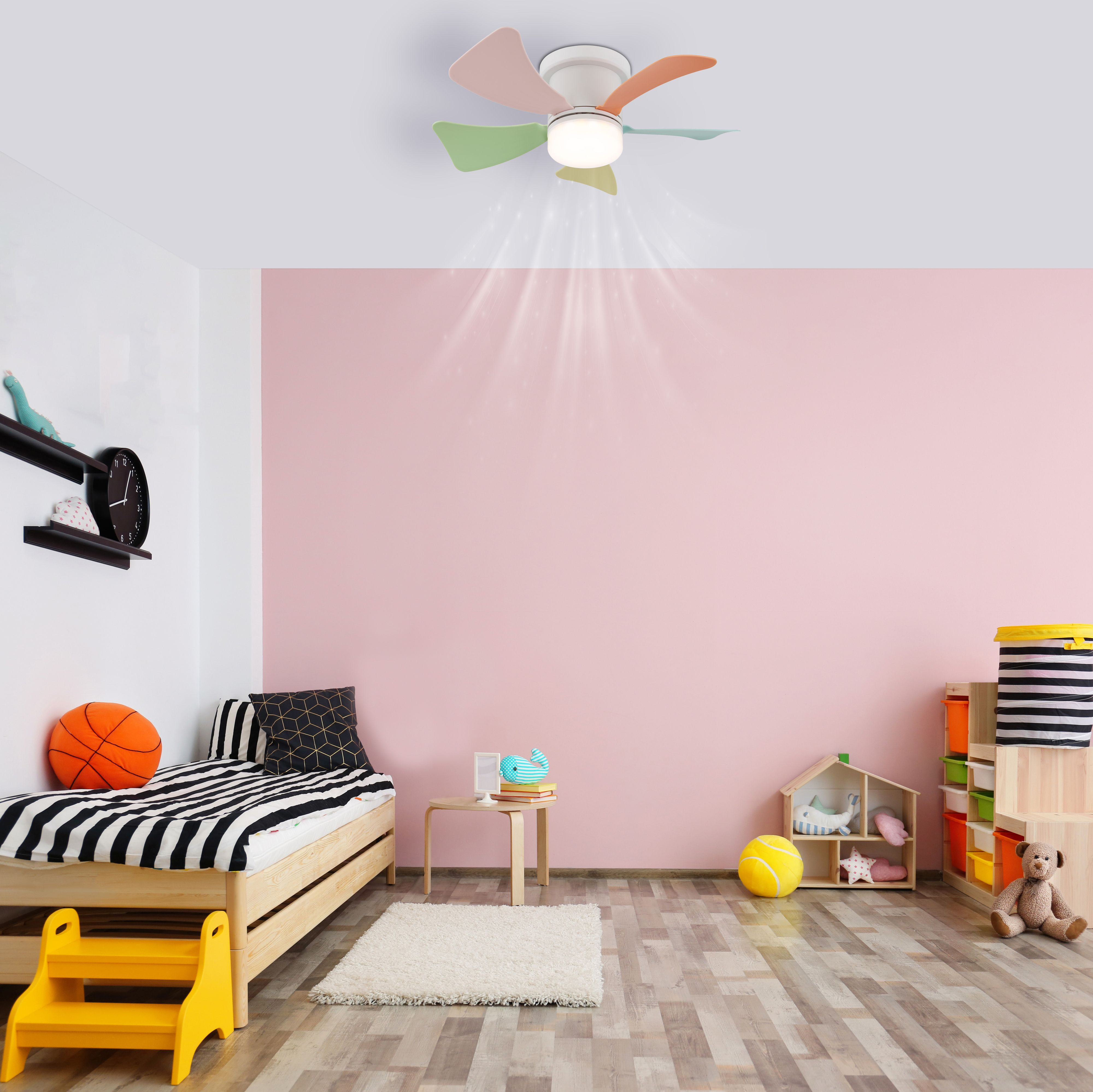 Ein Schlafzimmer mit rosa Wand, Bett und Ventilator.
