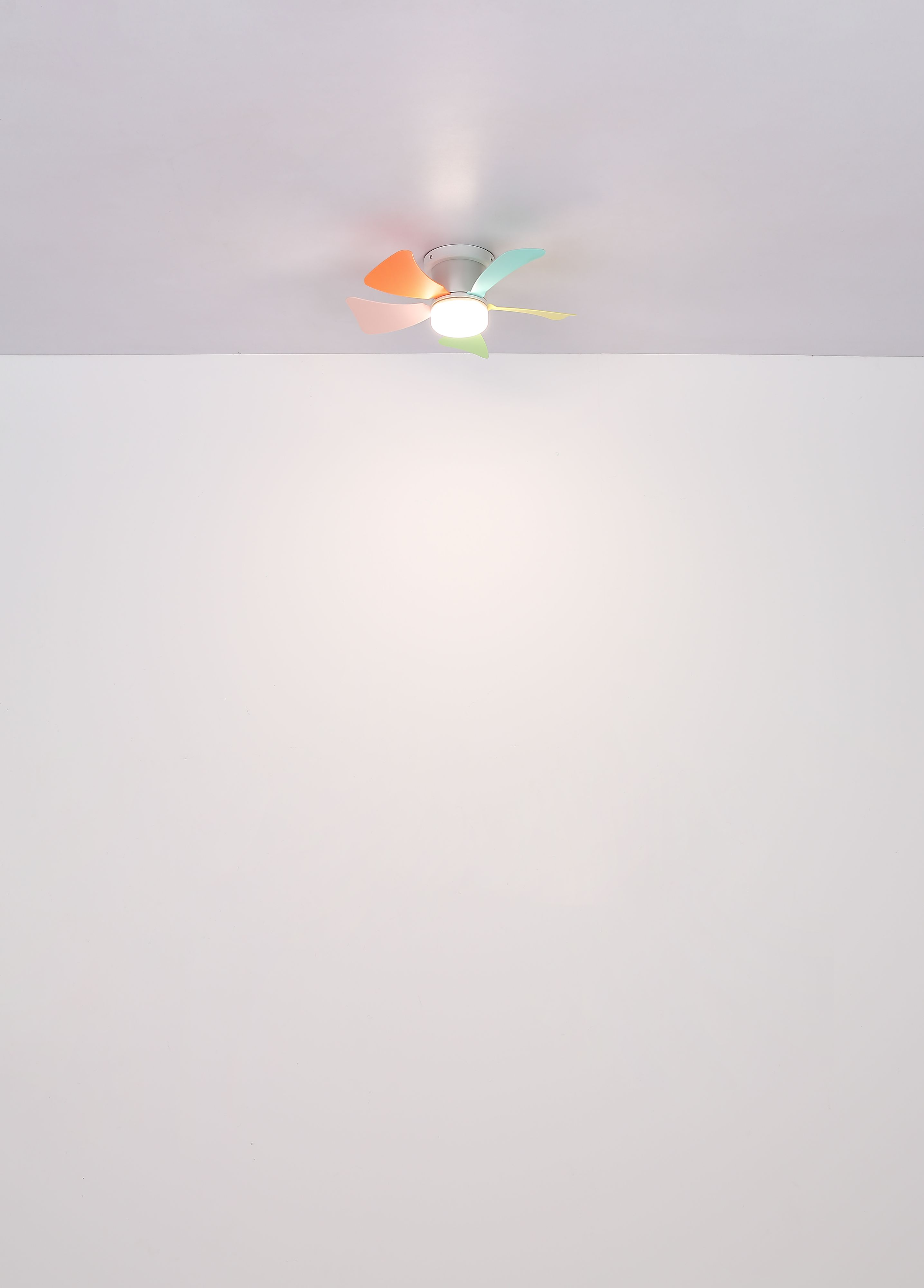 Ein Deckenventilator mit Pastellfarbenen Blättern an der Decke.
