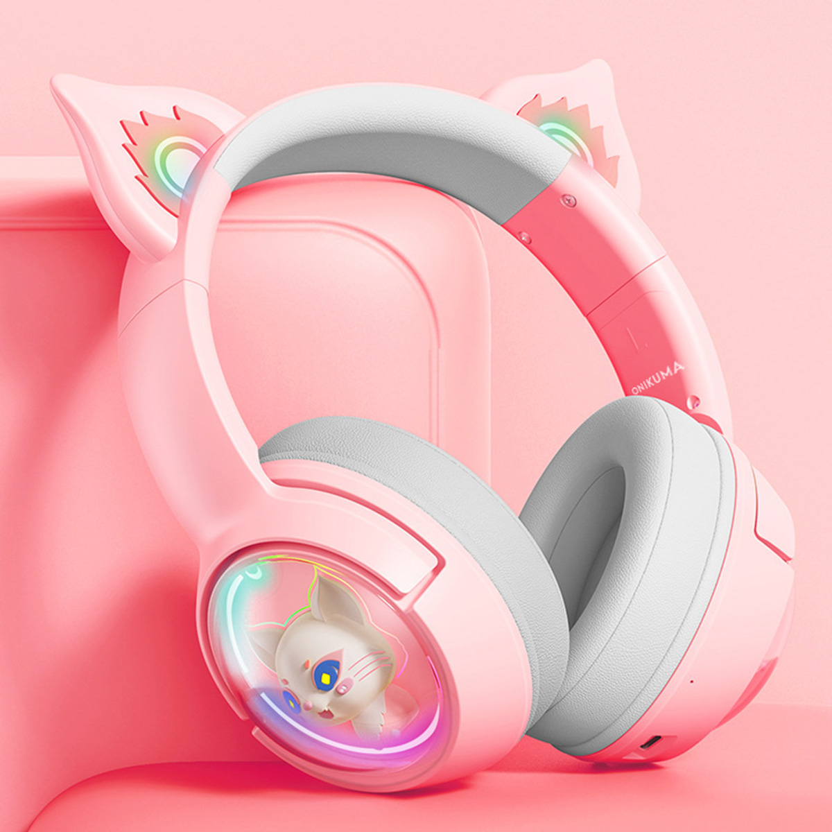 Rosa Katzenohrkopfhörer. Weiße Ohrmuscheln, Katzenmotiv, Regenbogenakzente, rosa Hintergrund.